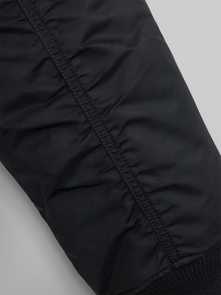 Close view of the zipper, sleeve pocket and red ribbon