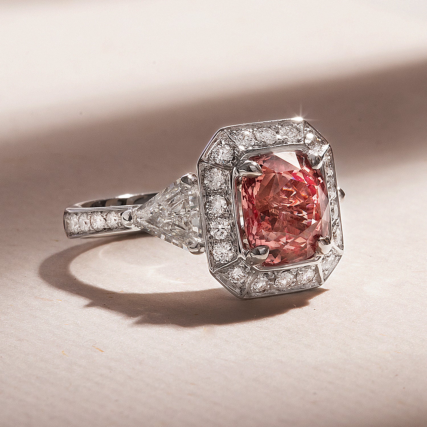 Padparadscha ring worn in warm light