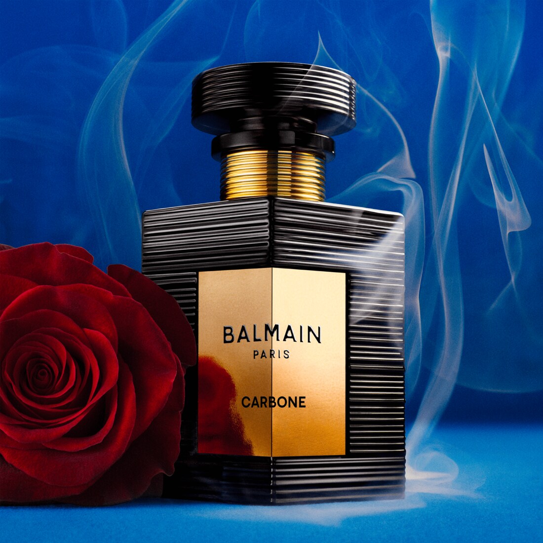 Styled with a red rose and blue smoke — the rose-and-musk accord