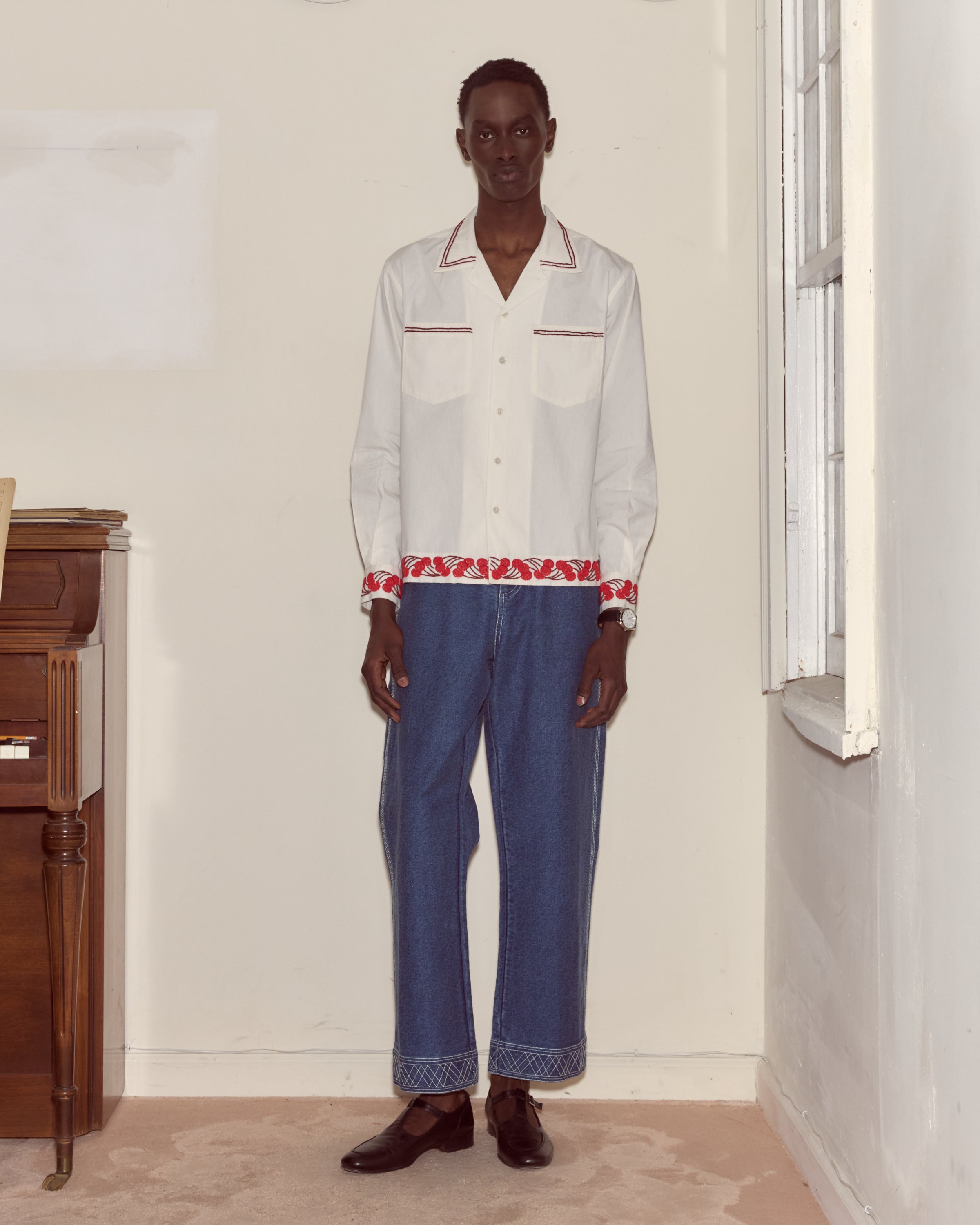 Beaded cherry trim around the shirt edge