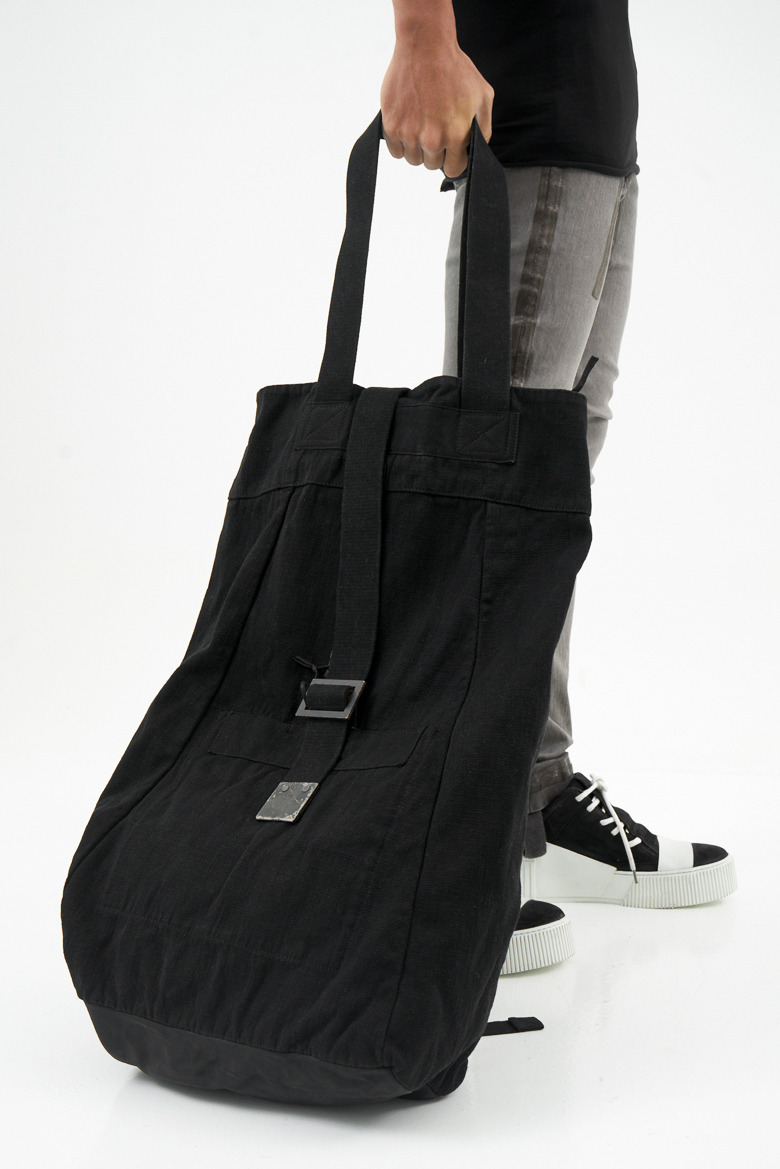 Black tote carried by hand
