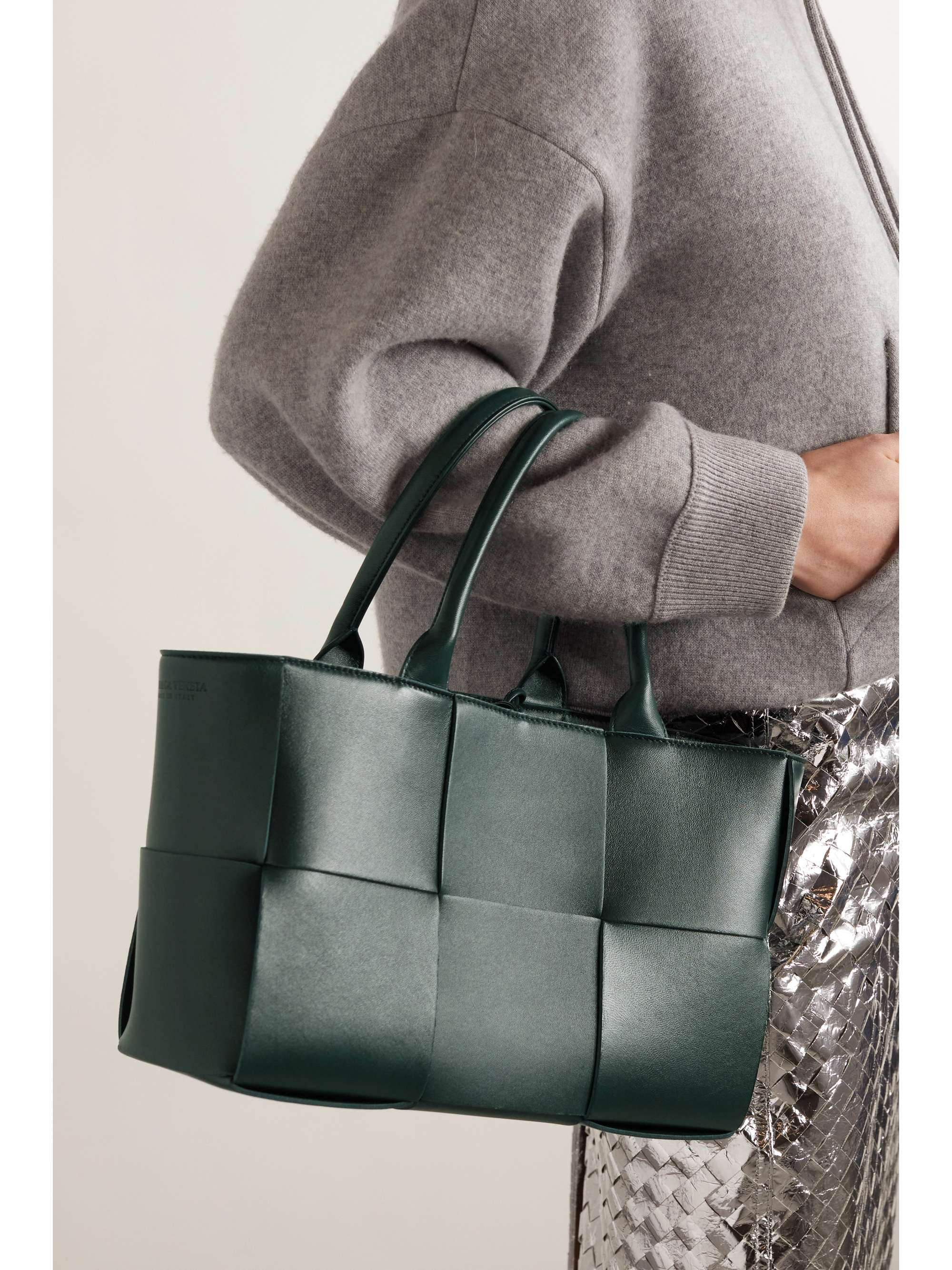 Carried in forest green, the tote held by its top handles