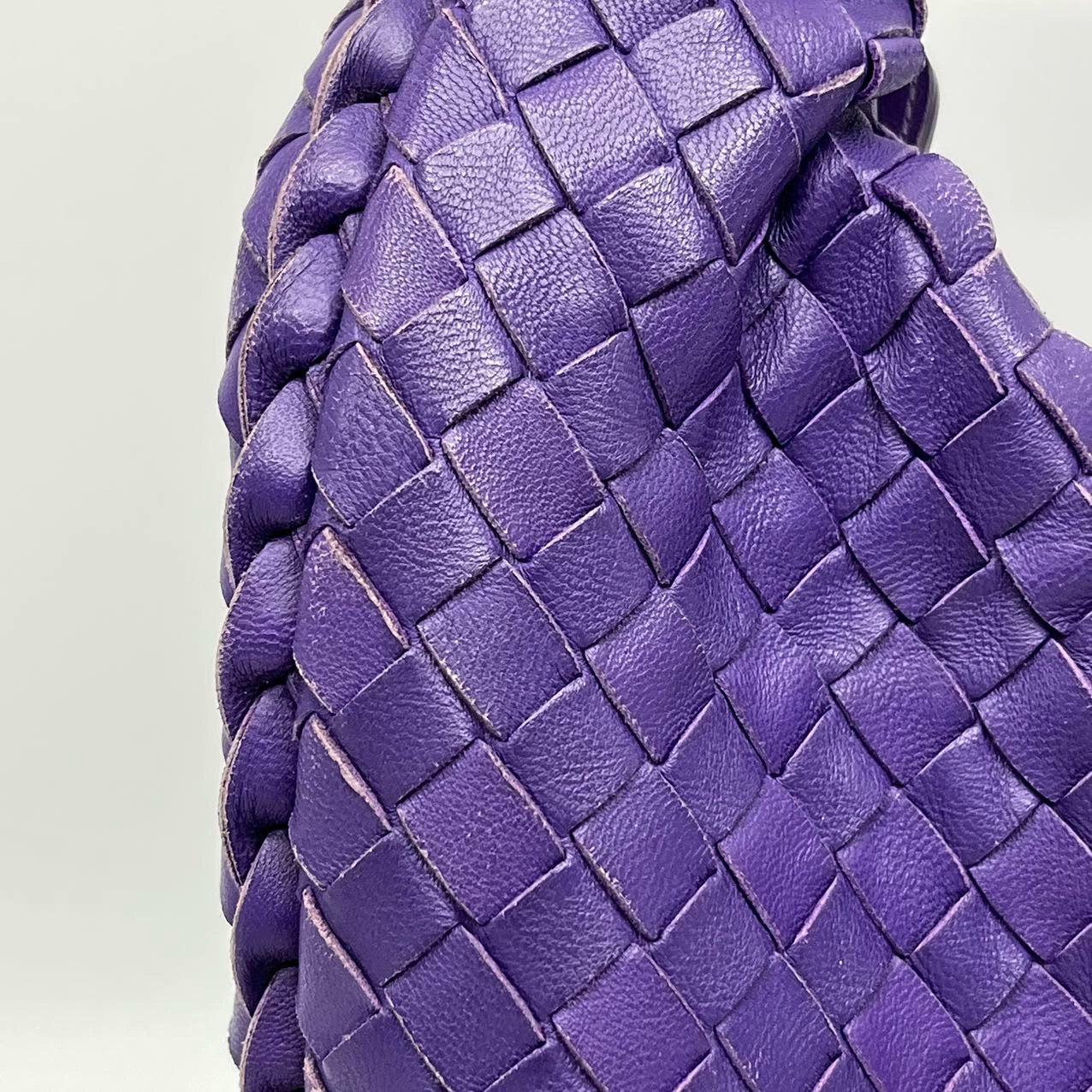 Detail of the Intrecciato weave — strips of leather threaded through one another by hand