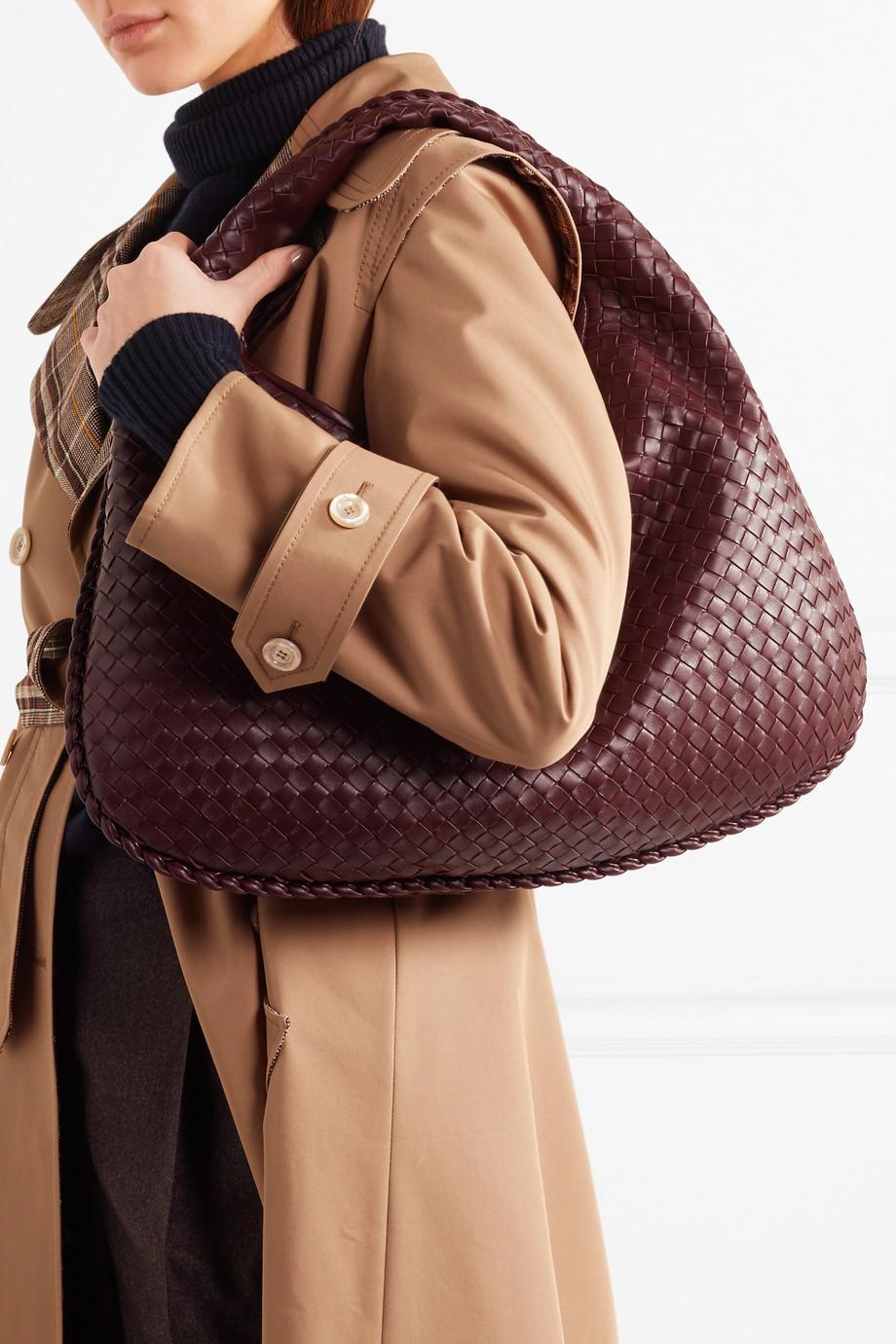 Carried on the shoulder in merlot, the woven body collapsing softly