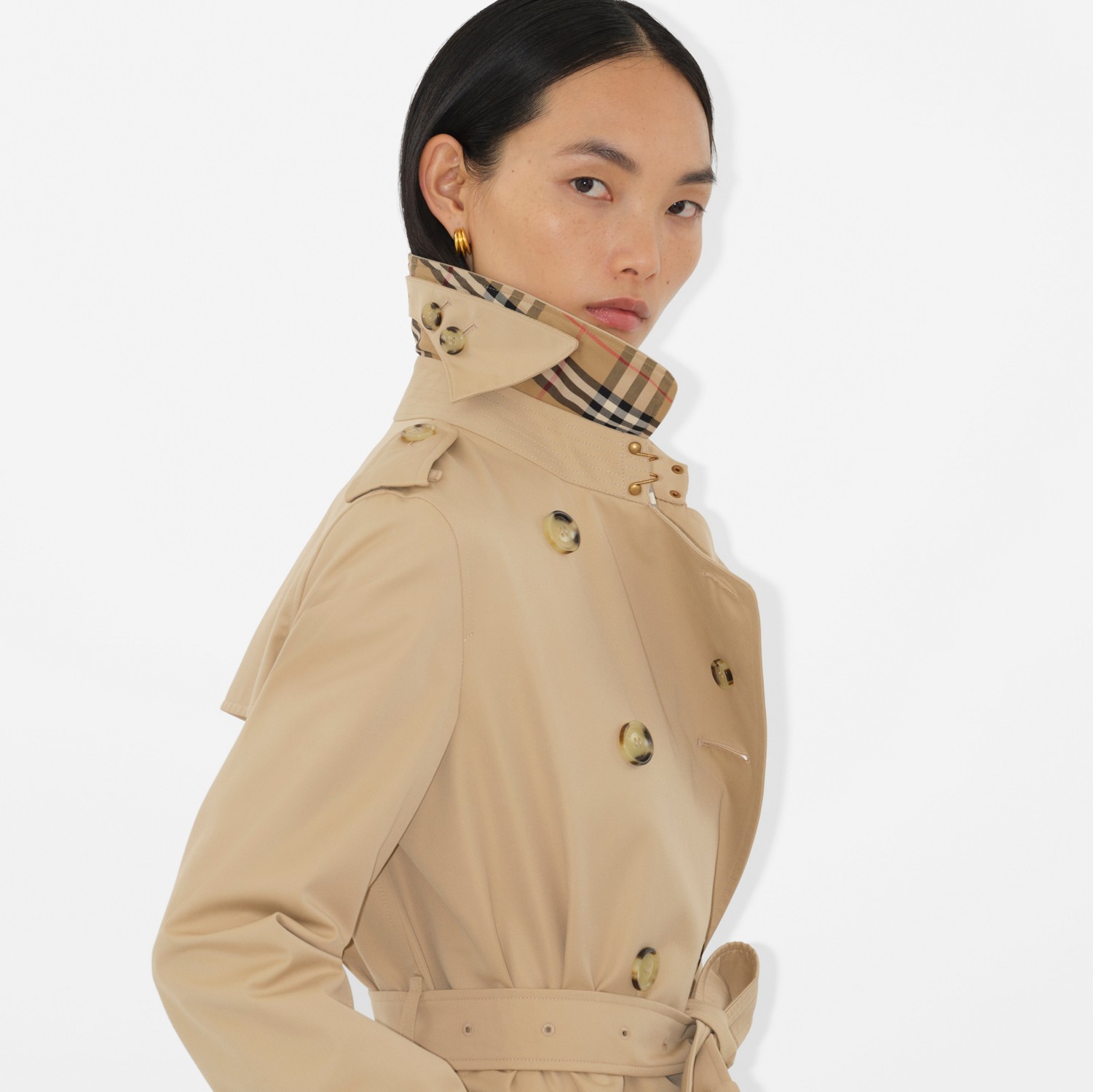 Throat-latch and storm-flap buttons fastened — the coat closed for weather