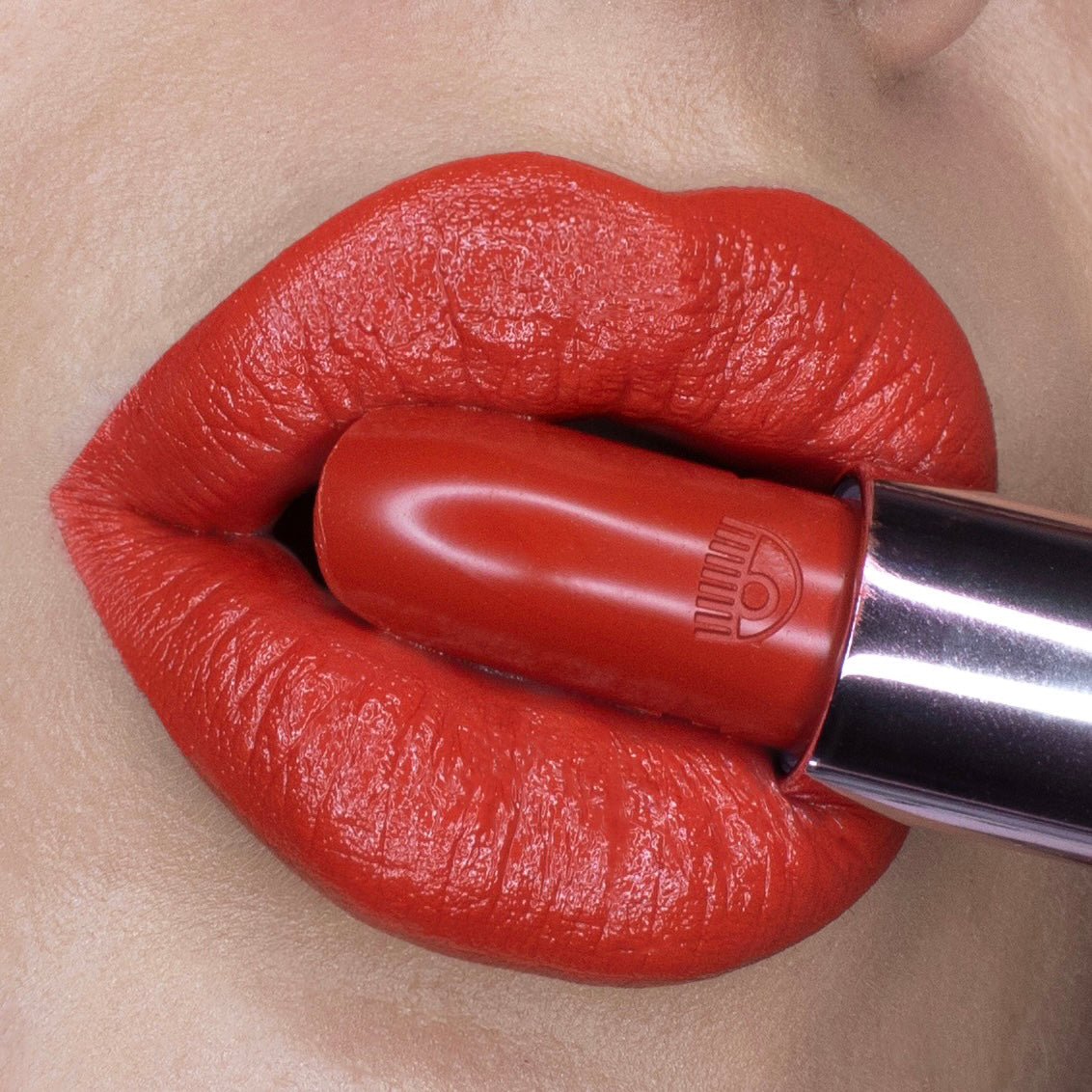 Applied warm-red lipstick close-up