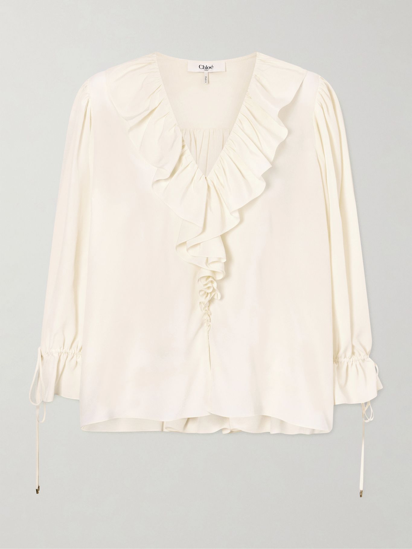 Detail of the deep-V ruffled neckline