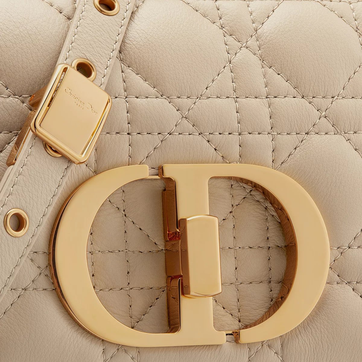 Close detail of the CD twist-lock clasp on warm taupe calfskin