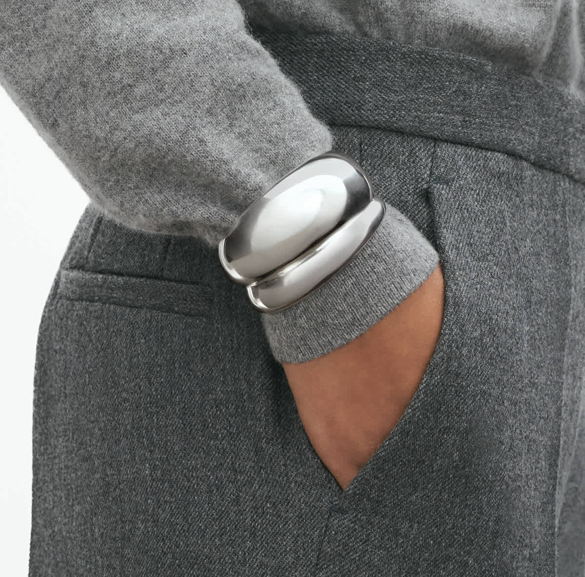 Curve bangle worn over a grey sleeve