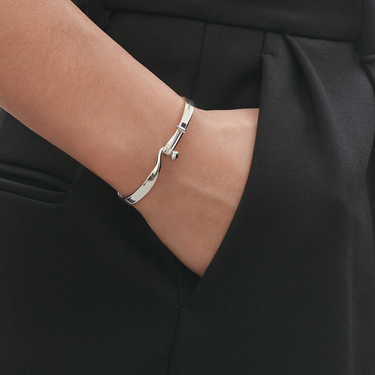 Silver Torun bangle worn with black tailoring