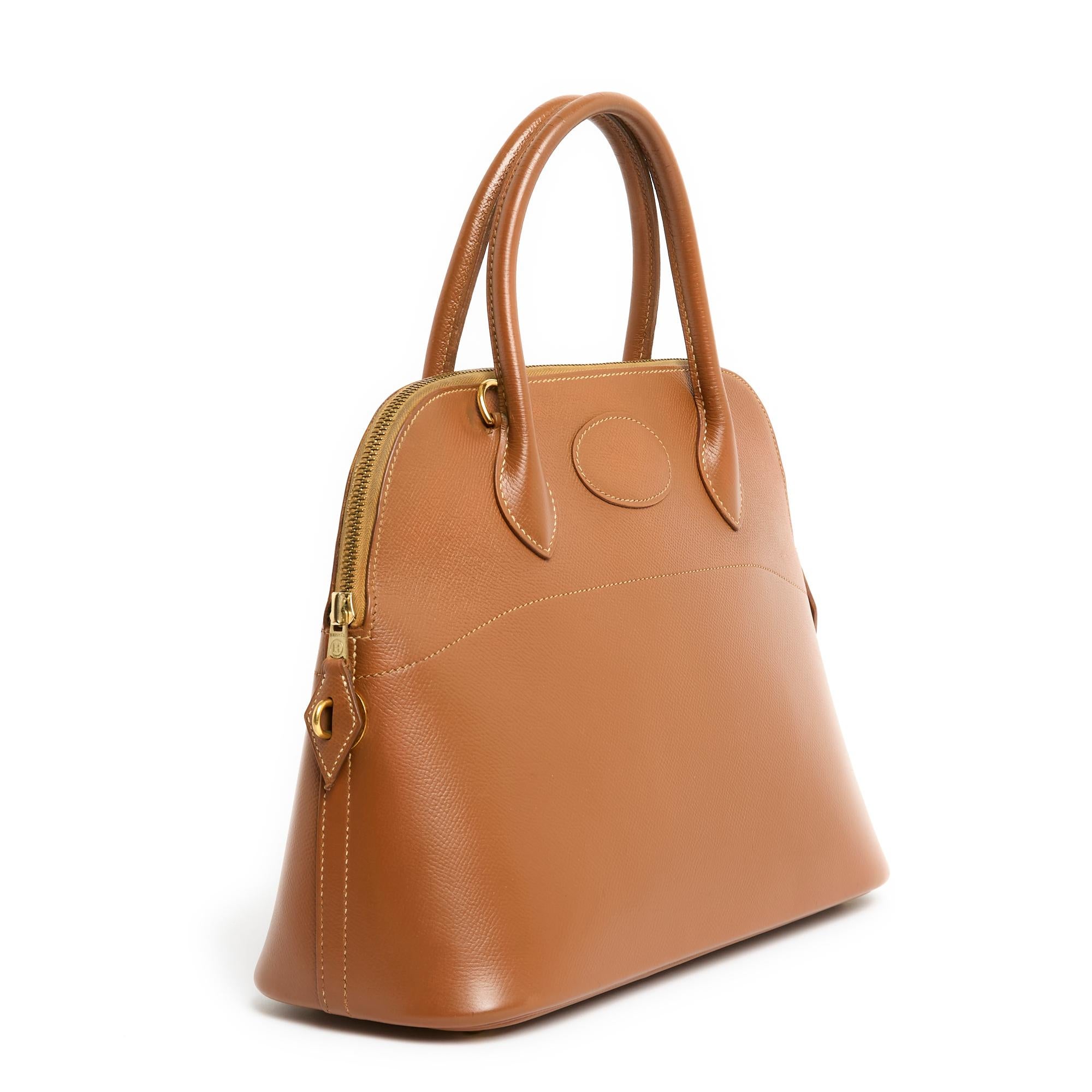 Tan Bolide three-quarter view — the zip curving across the top