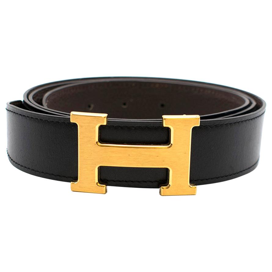 Detail of the gold H buckle on a coiled black strap