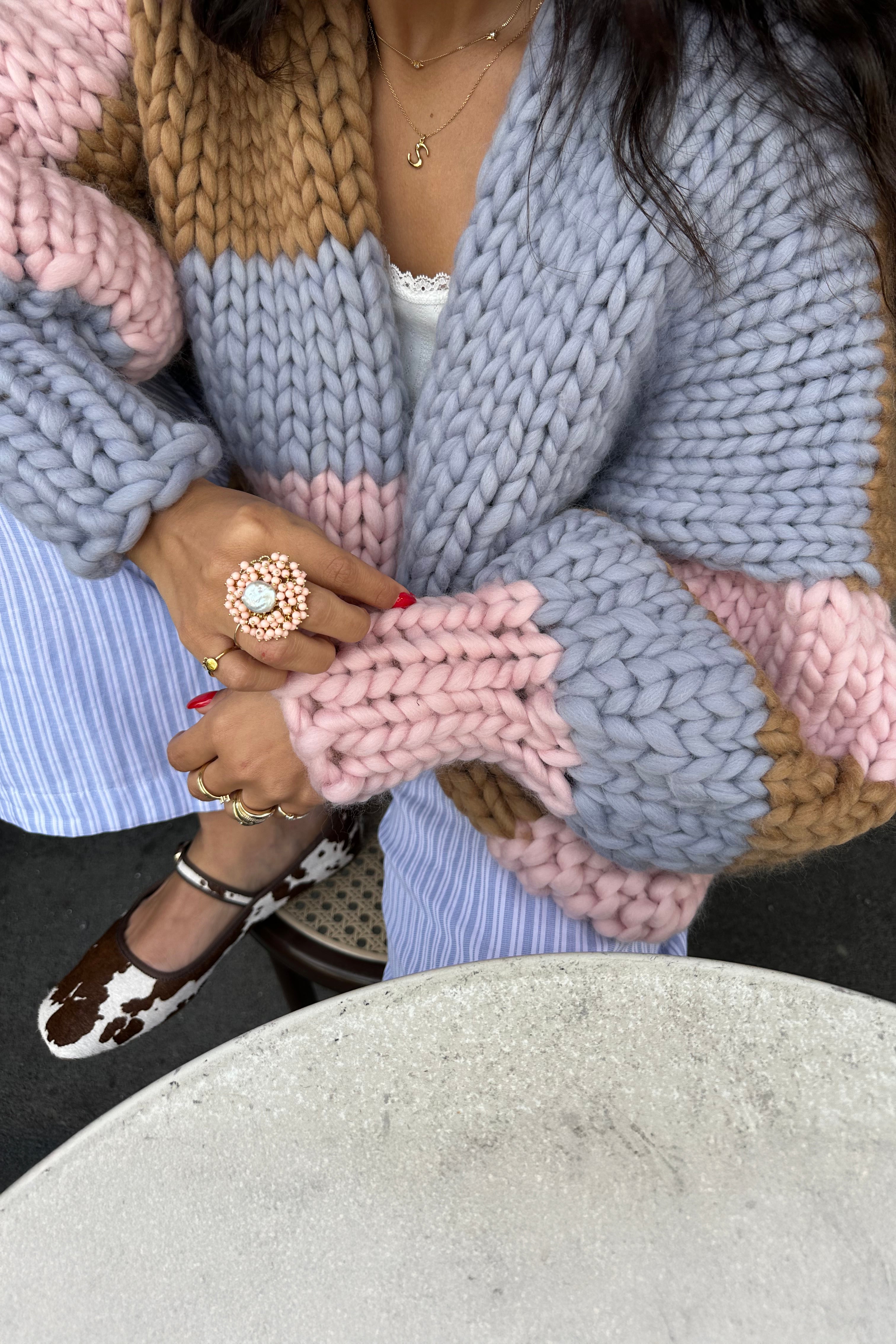 Close crop on the lofty stitch texture and striped cuff