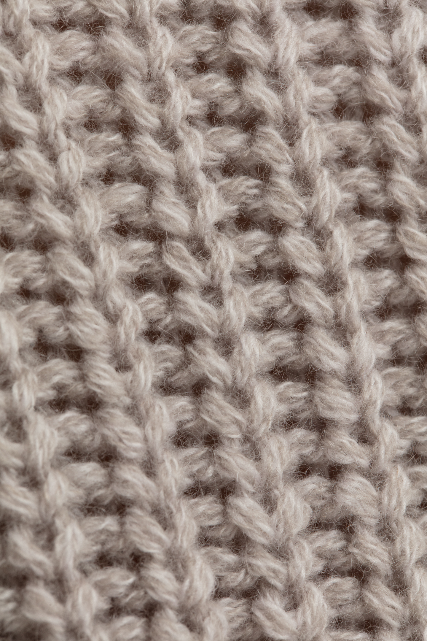 Knit close-up highlighting the half-cardigan structure