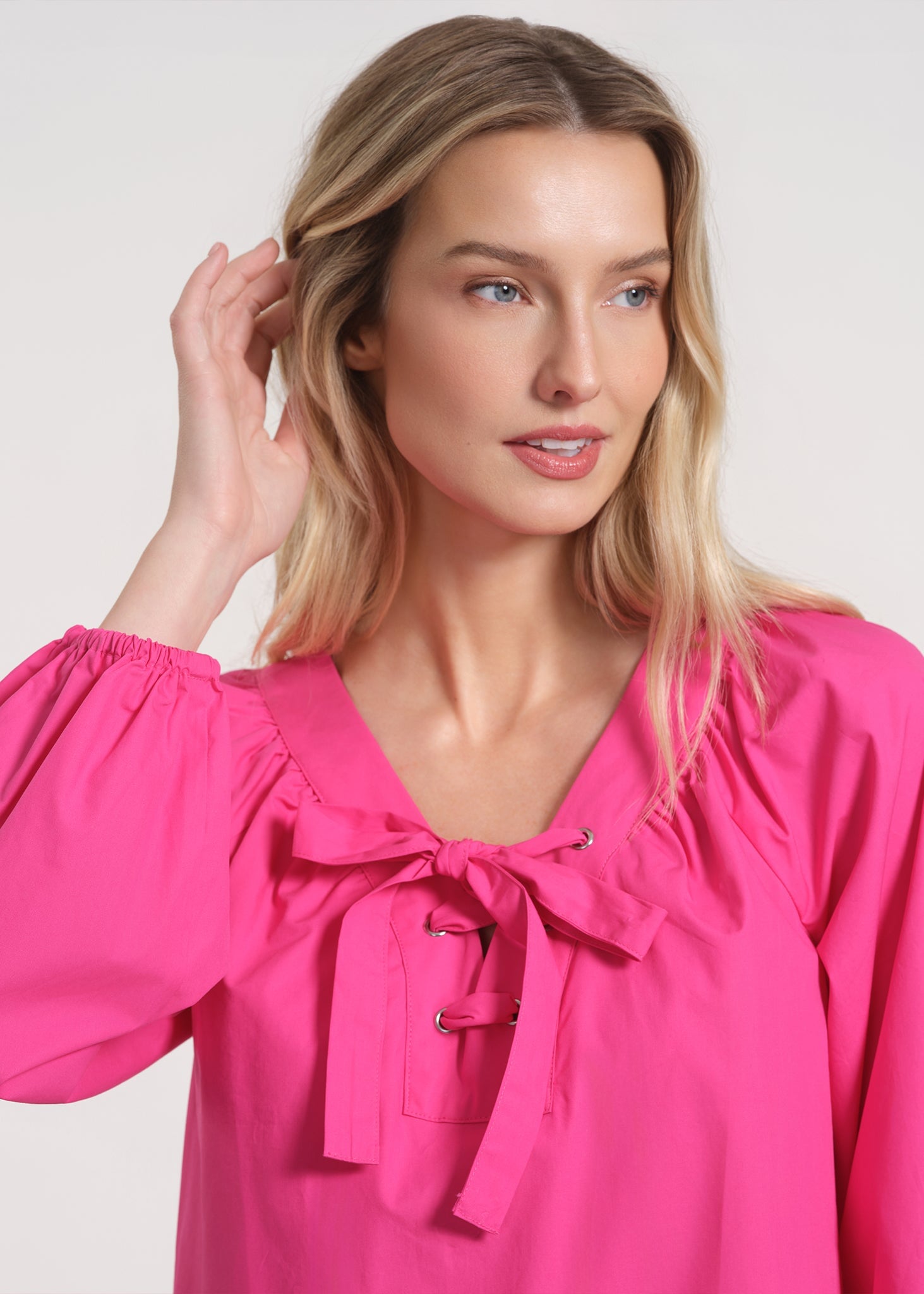 Close crop on the neckline bow and balloon sleeve volume