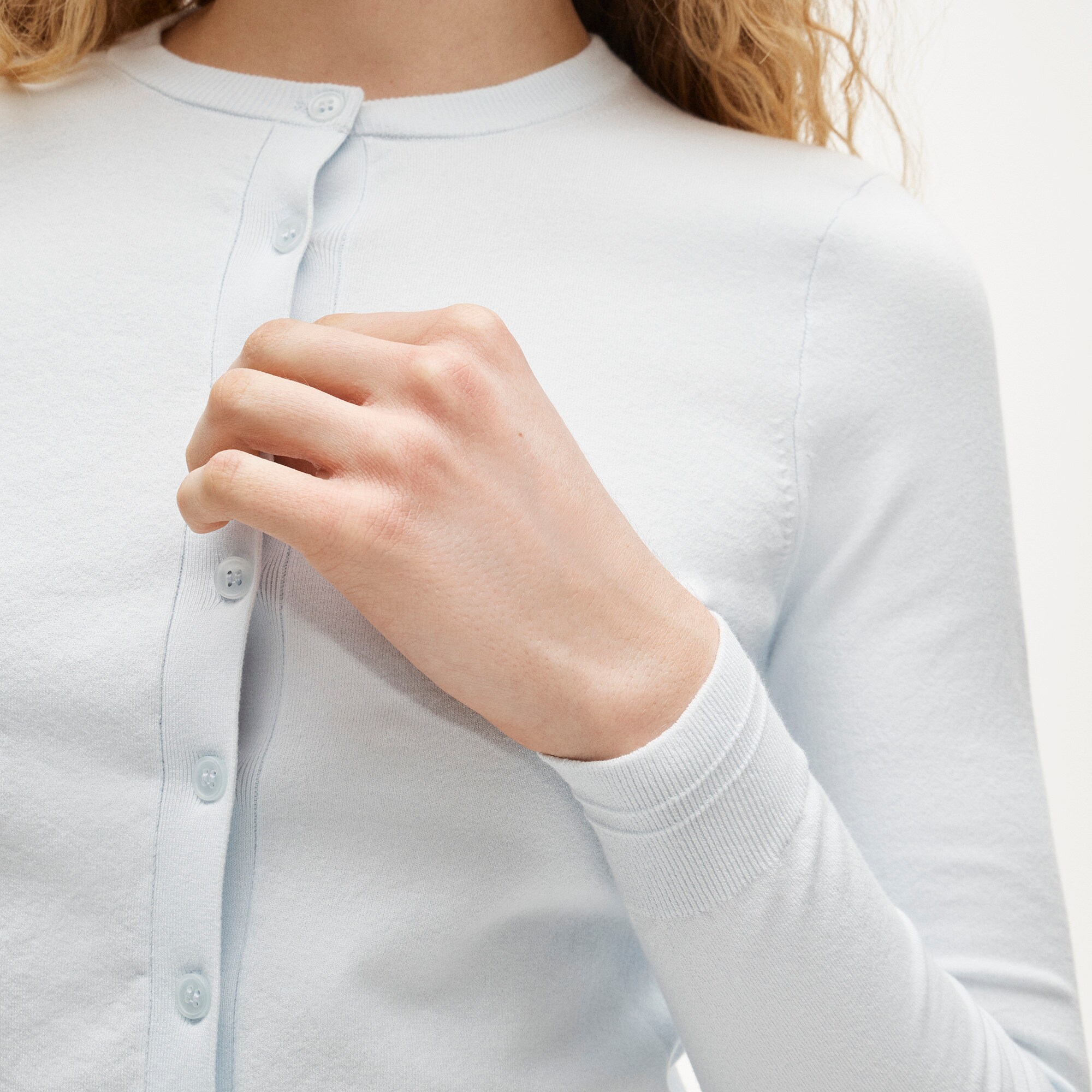 Close detail of the fine-gauge knit and tonal buttons