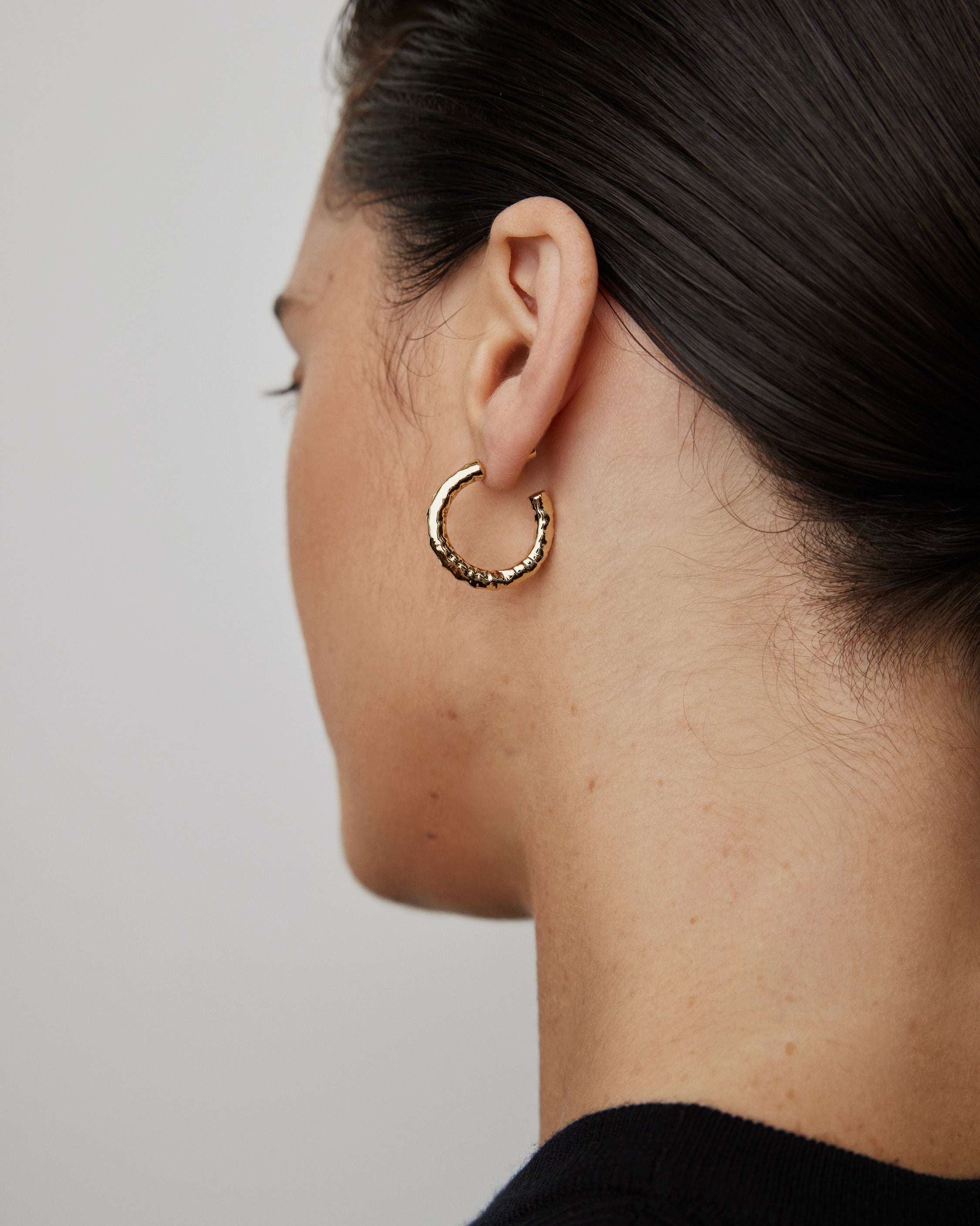 Alternate on-ear view reinforcing the compact huggie proportion