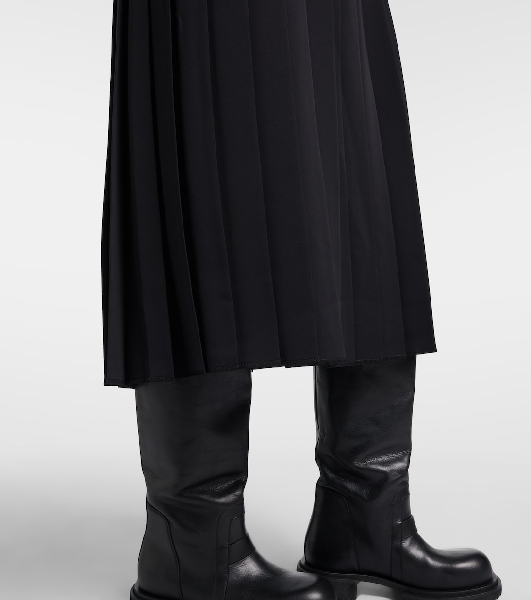 Hem detail showing the long uninterrupted vertical pleats.