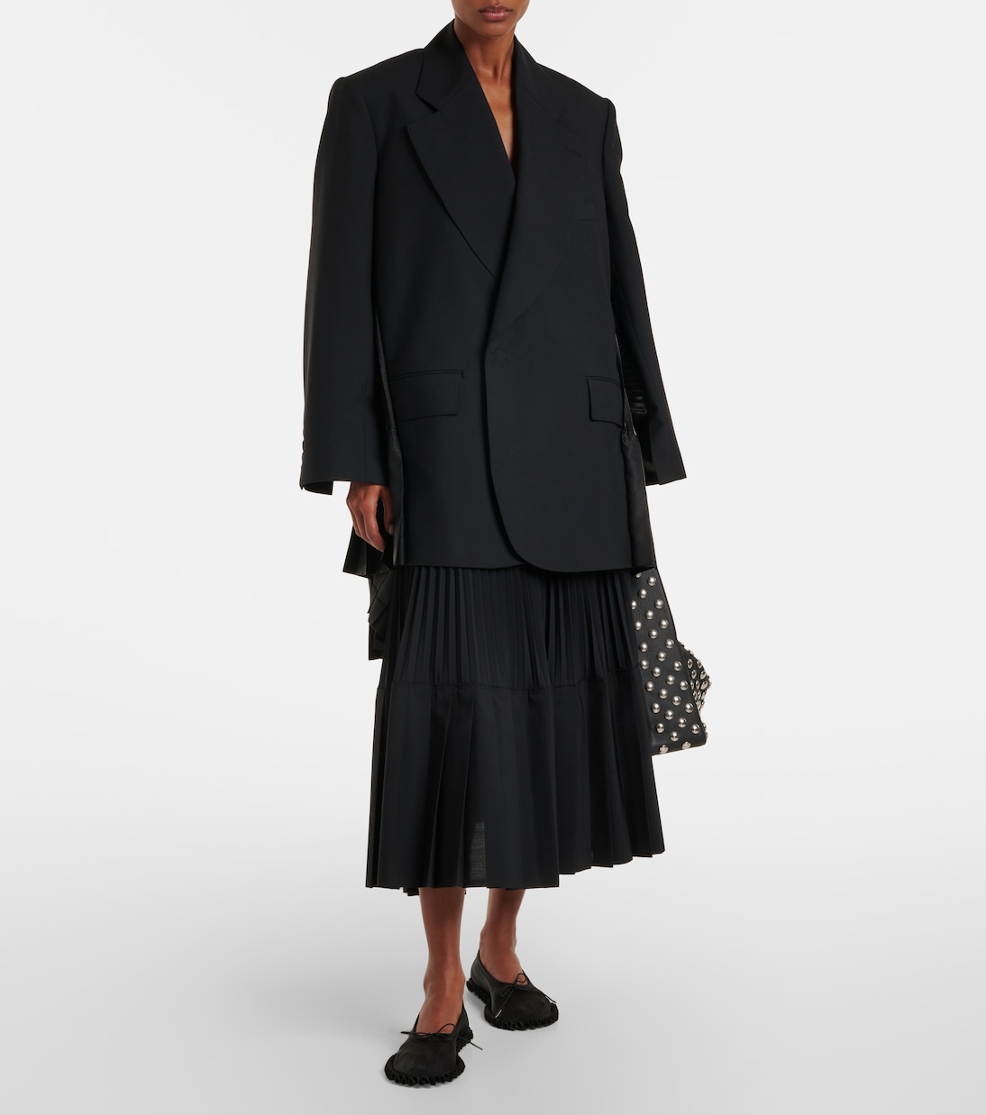 Full look showing the dropped, caped tailoring.