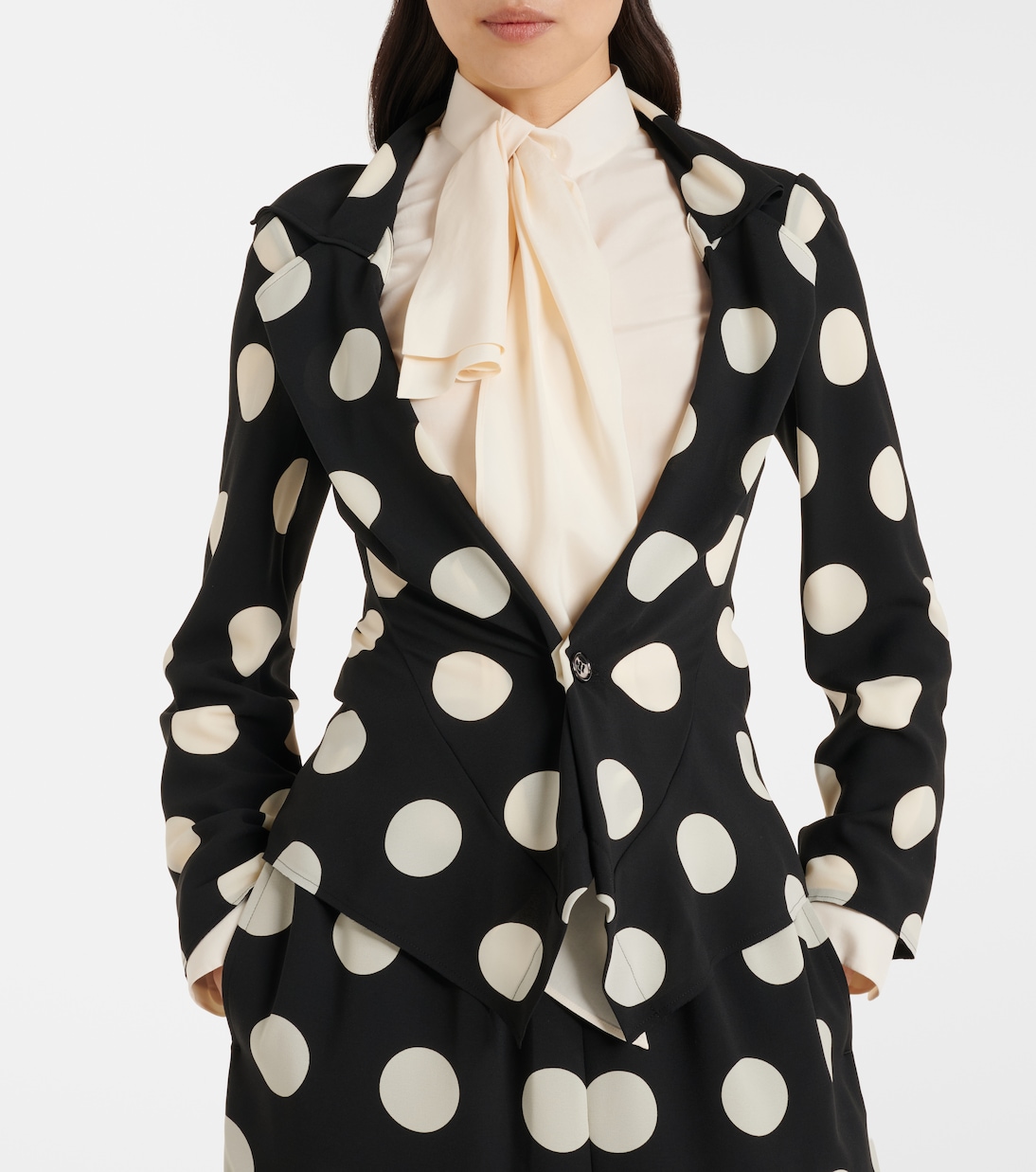 Close crop on the asymmetric front and single-button closure.
