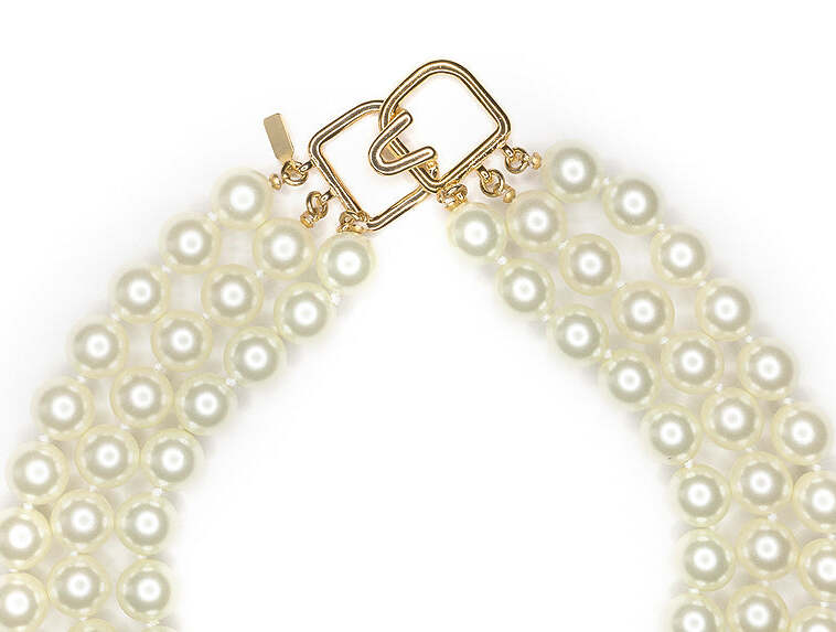 Upper crop showing the necklace's compact collar proportion