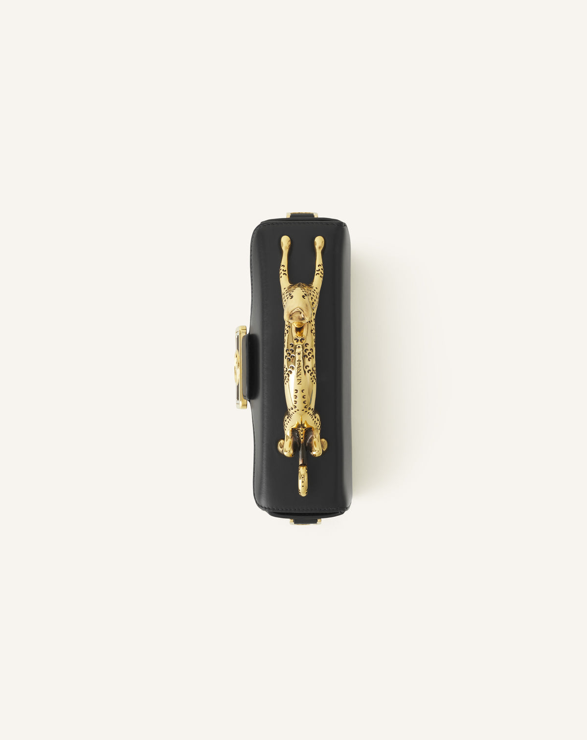 Top-down — the gold feline sculpture and LANVIN engraving