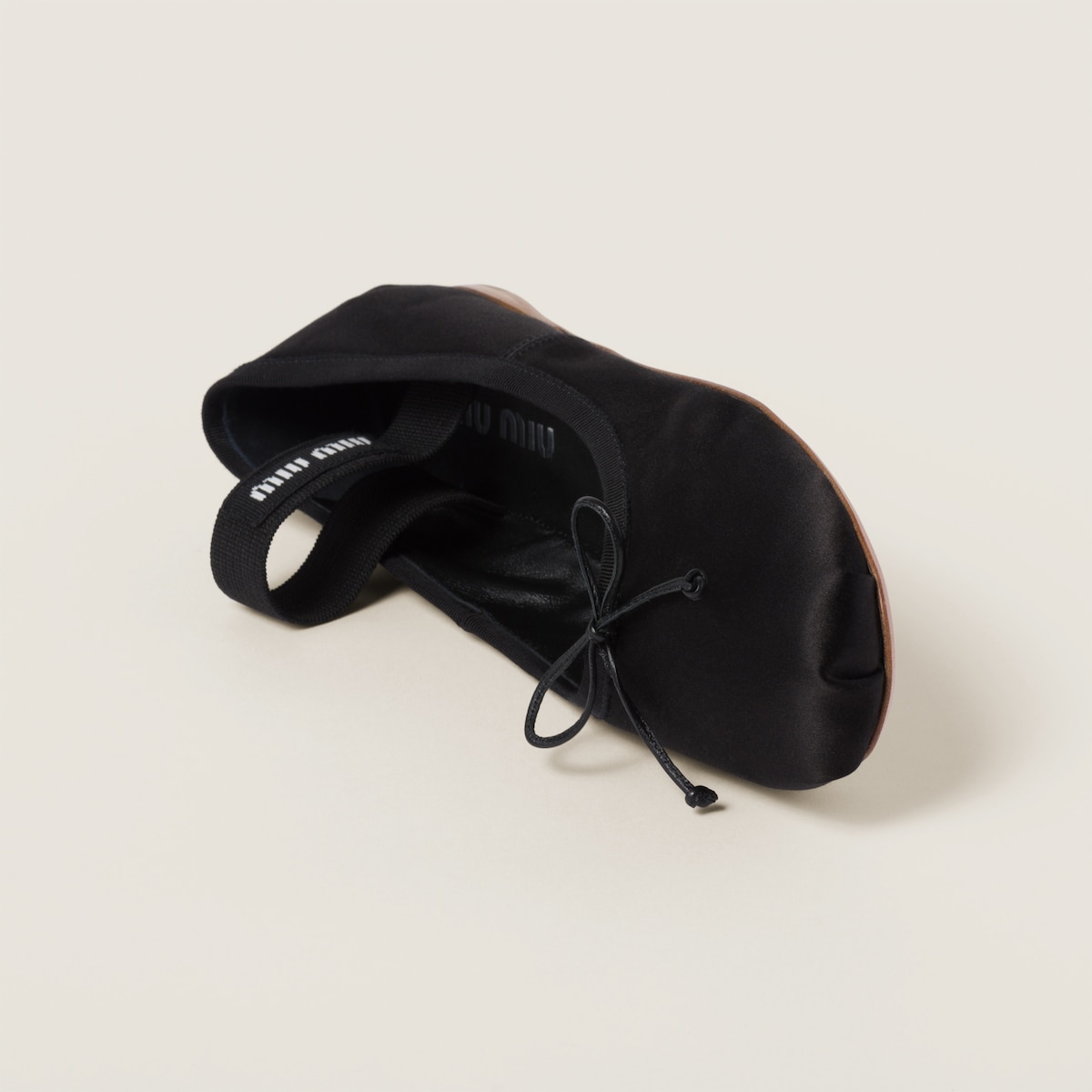 Detail of the satin sheen, leather bow tie and the miu miu logo elastic