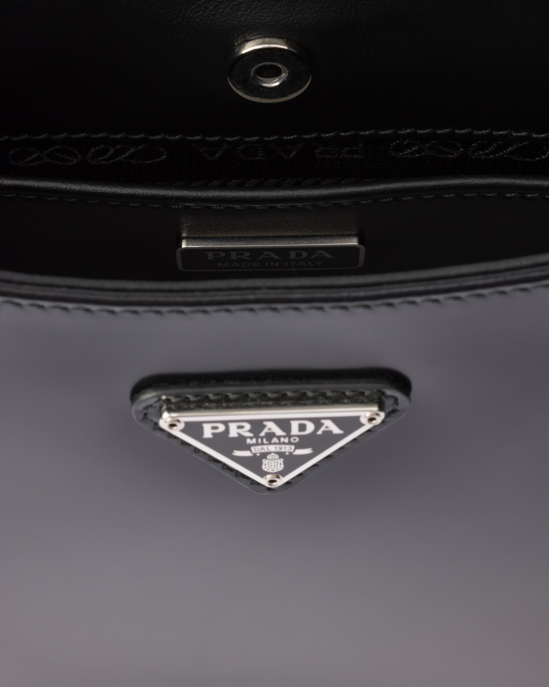 Interior closeup — the PRADA Made in Italy plate and triangle logo