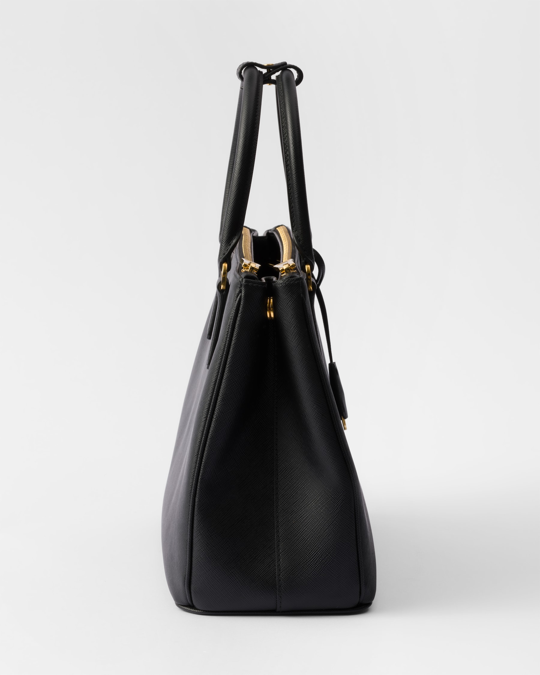Side profile showing the cross-hatched Saffiano texture and gold feet
