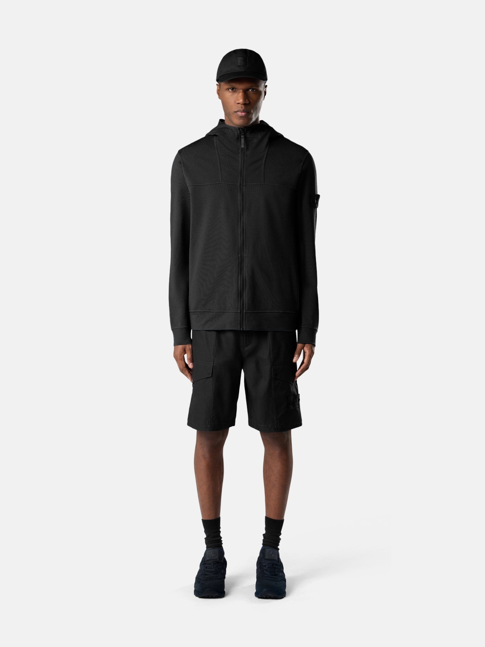 Detail — the tonal compass badge that blends into the garment