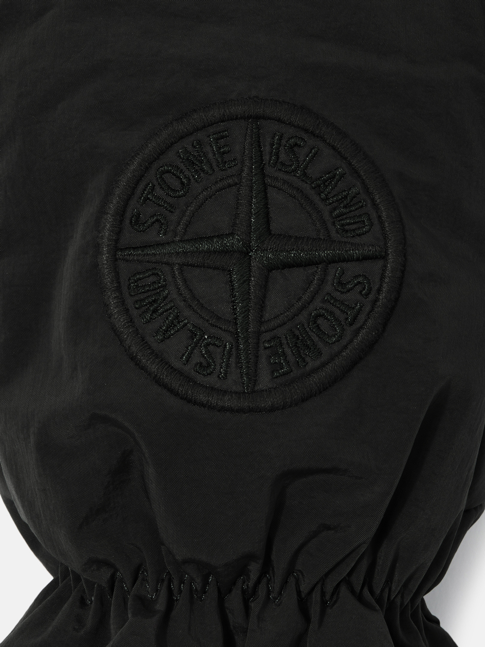 Detail — the embroidered compass logo on the back of the hand