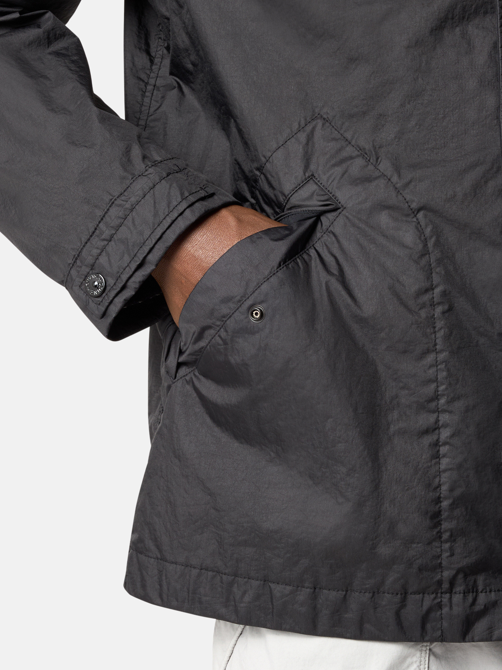 Detail — the compass badge, cuff and snap pocket