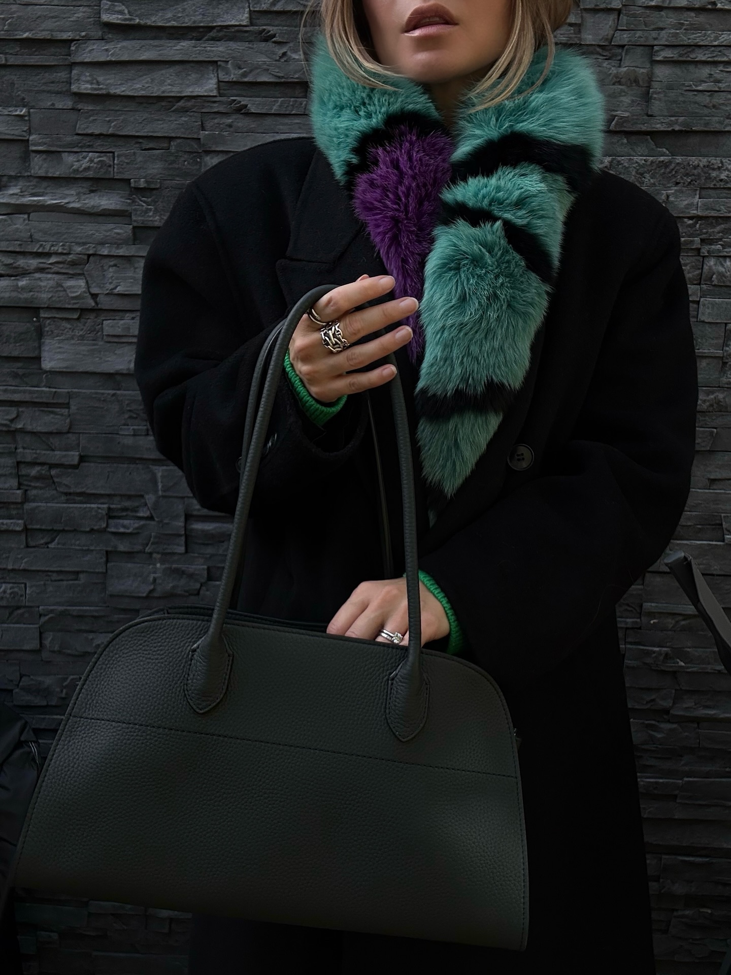 The Row Margaux carried with a black coat and green scarf for a real-world bag size check
