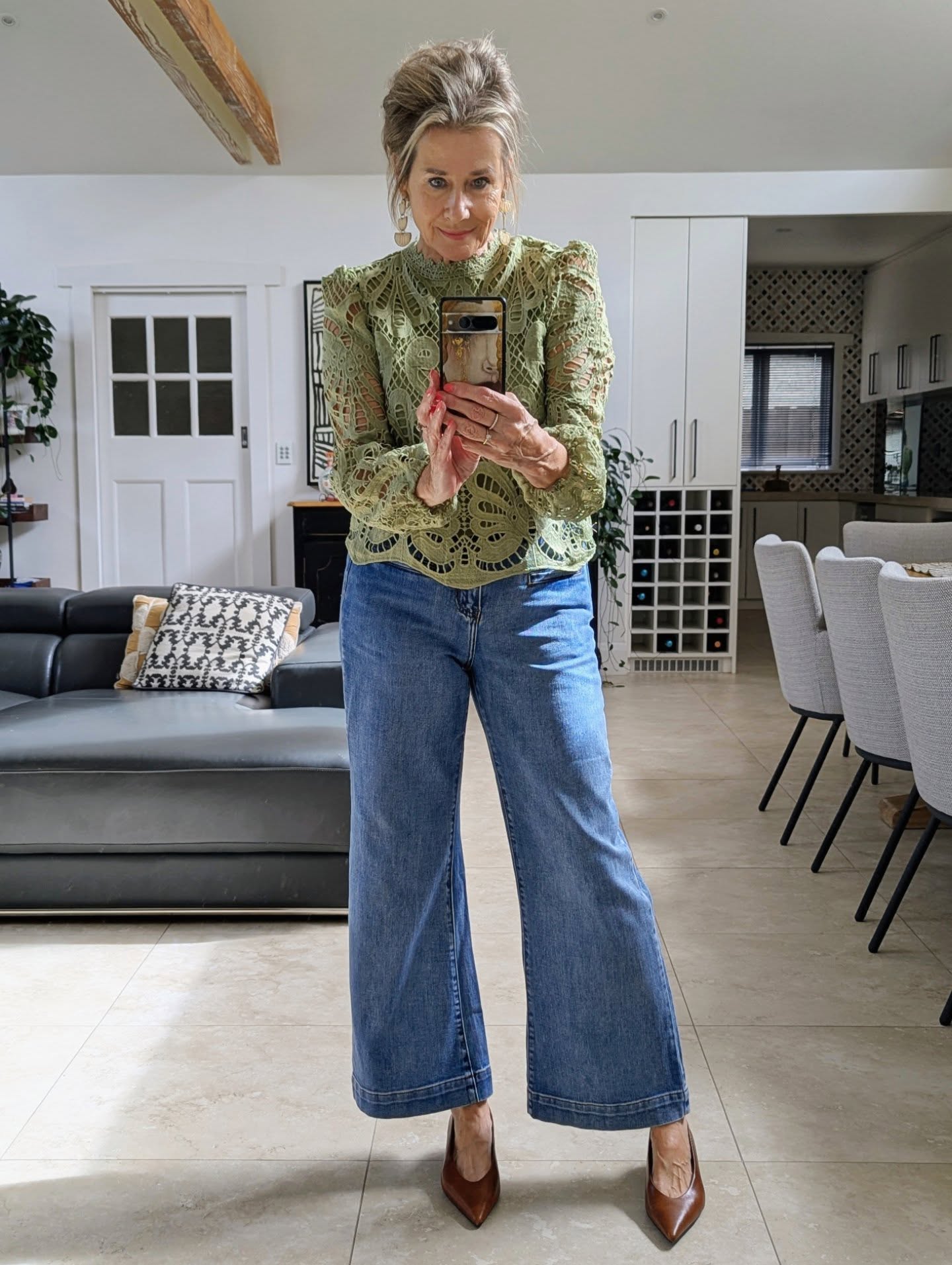 Creator wearing a green cotton-lace blouse with relaxed blue denim