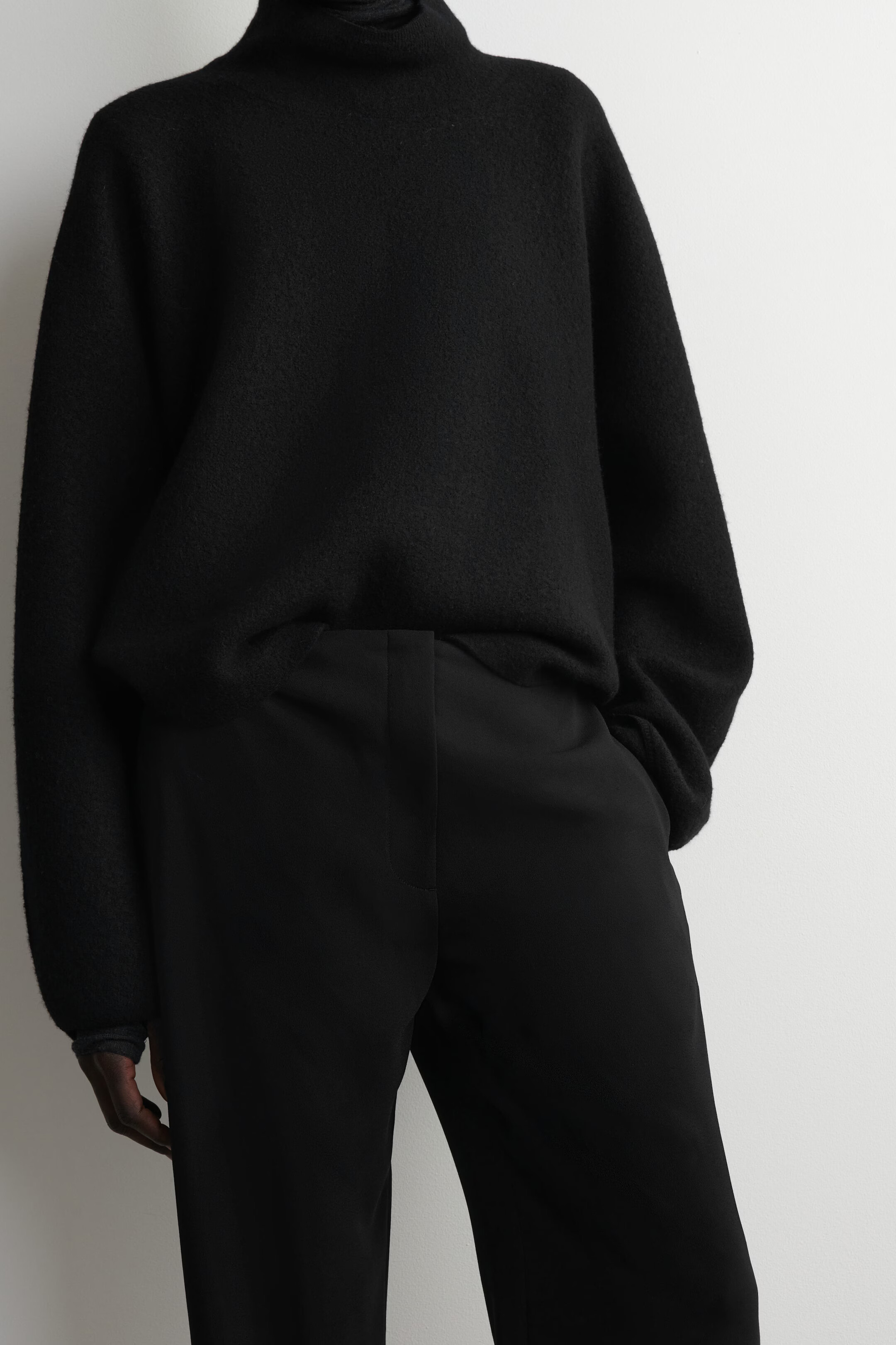 Close view of COS black tailored trousers