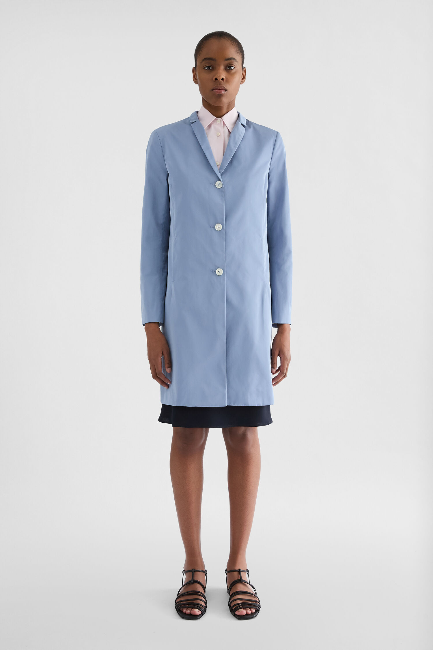 Jil Sander Radzimir Coat in pale blue on a model, slim straight cut, button front, and smooth technical fabric visible.
