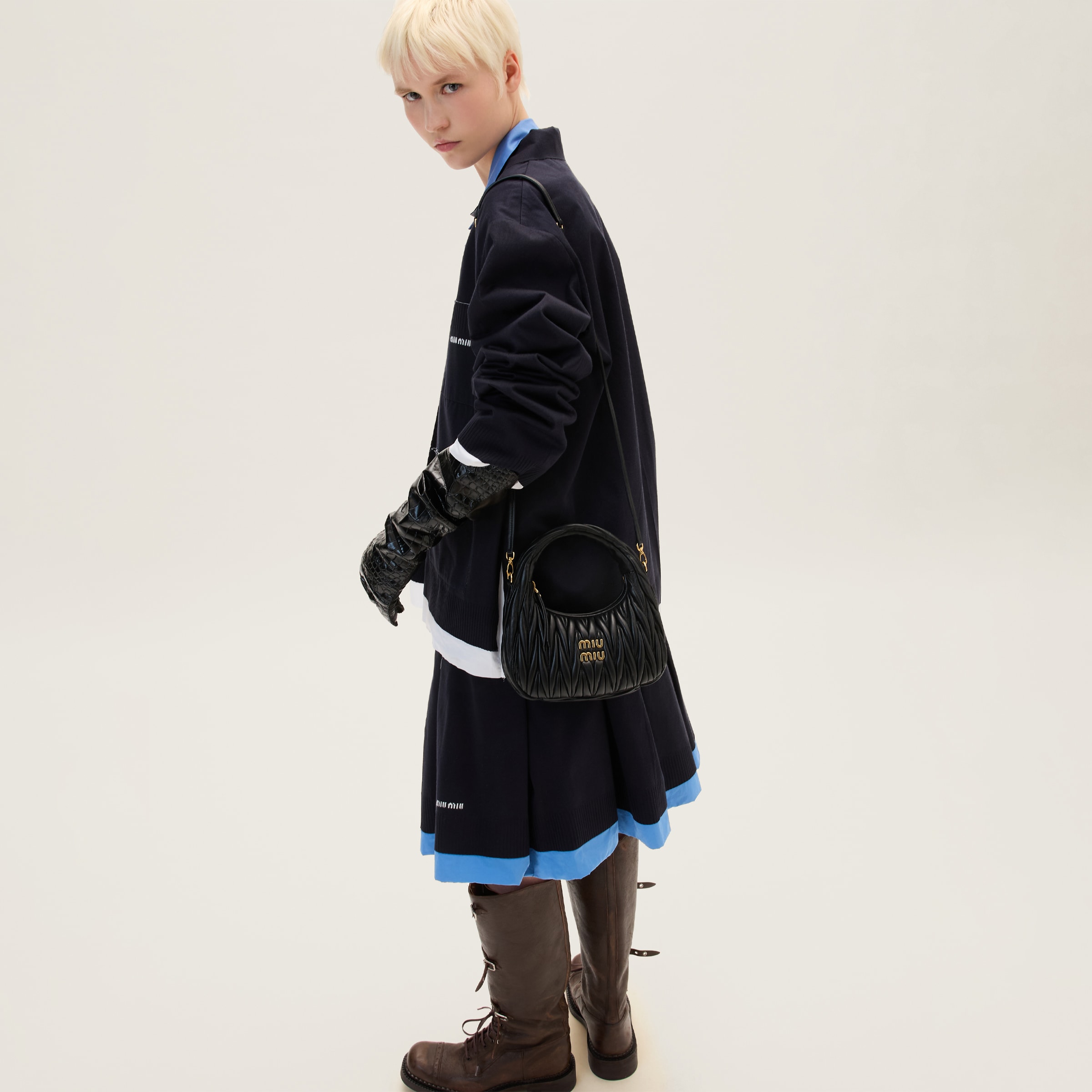 Miu Miu Wander black hobo bag worn with long strap on model, showing compact body scale.