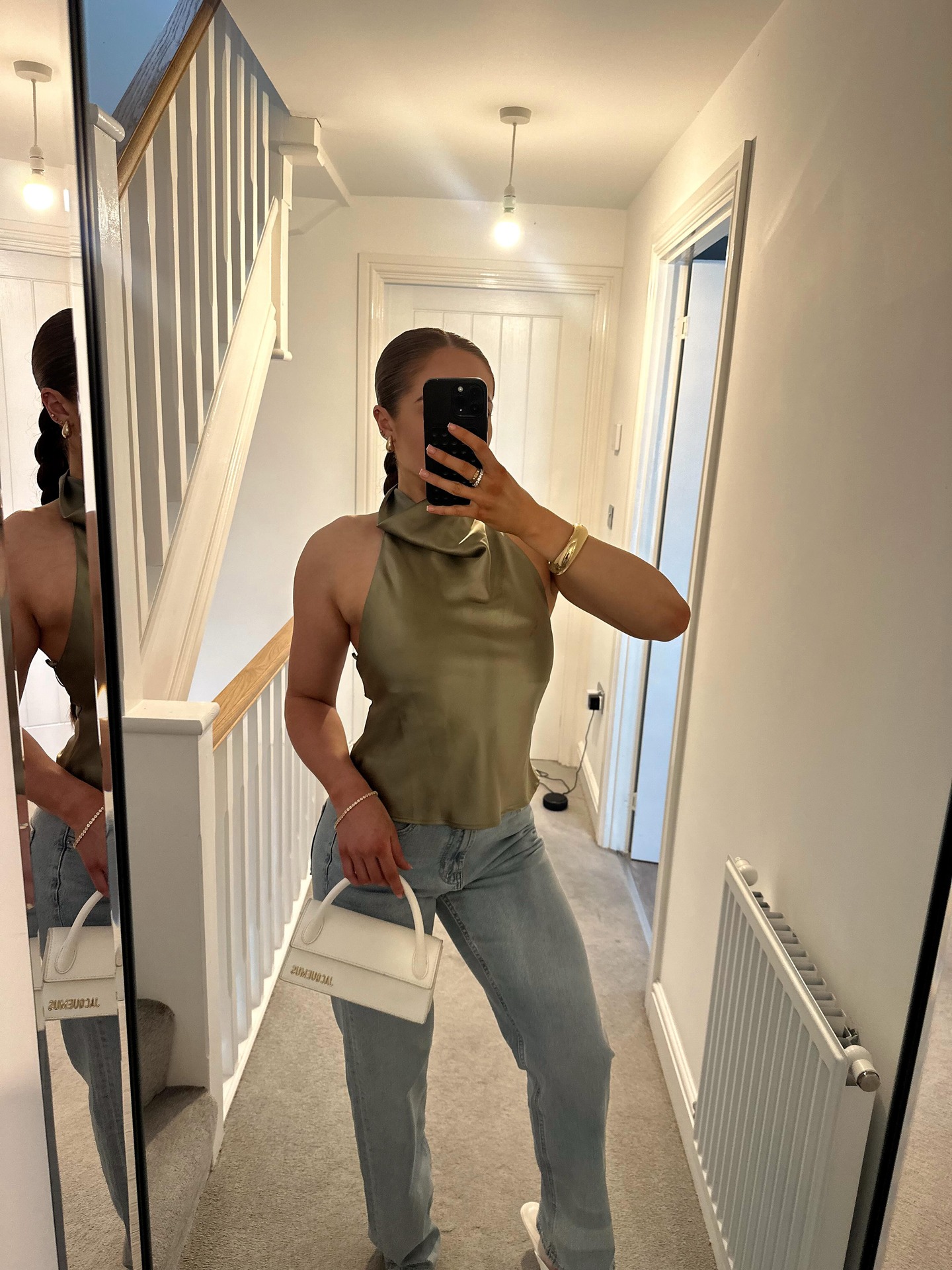 Mirror outfit styling with a sleeveless olive top, light denim, and a white Jacquemus handbag on @sophieeparsons