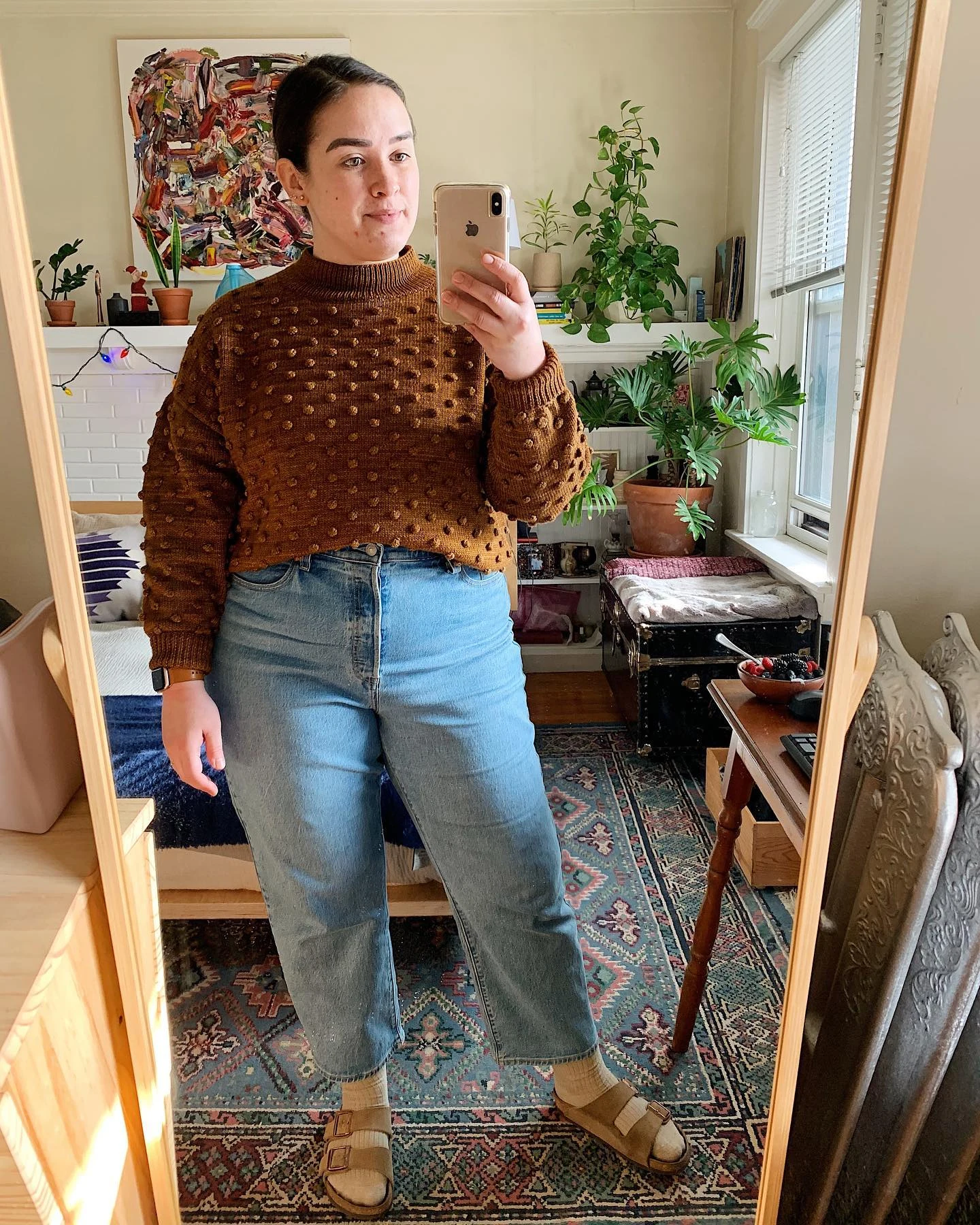 Creator @shannydoots in Levi’s Ribcage jeans, a brown sweater, socks, and Birkenstock sandals