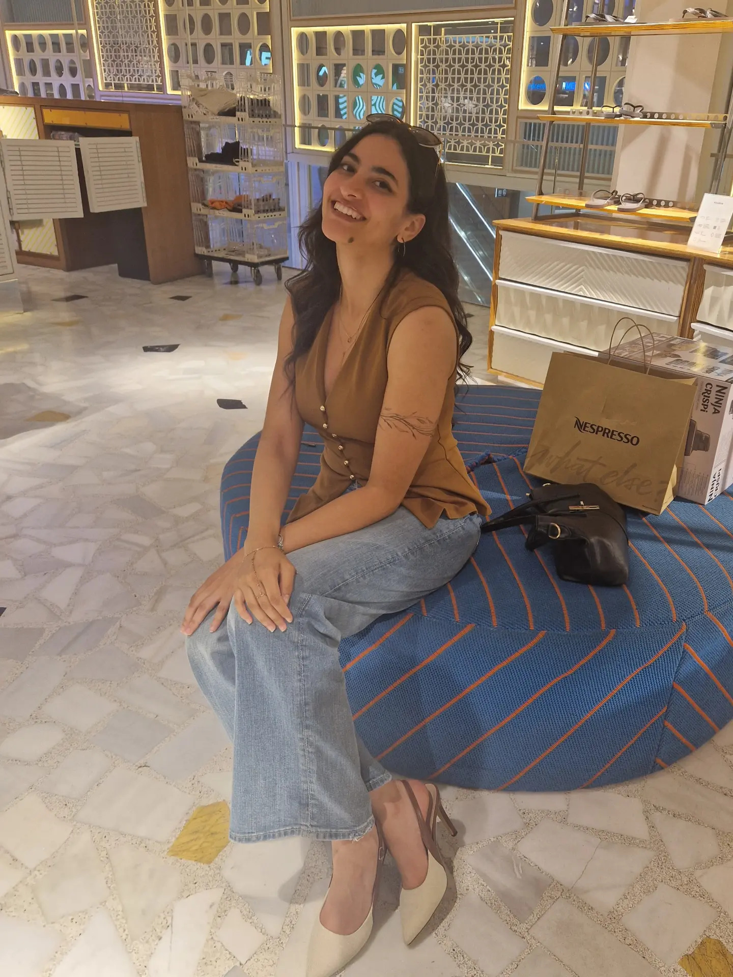 Fatima Ajal in a brown sleeveless top jeans and two-tone pumps at Westfield Mall of Scandinavia