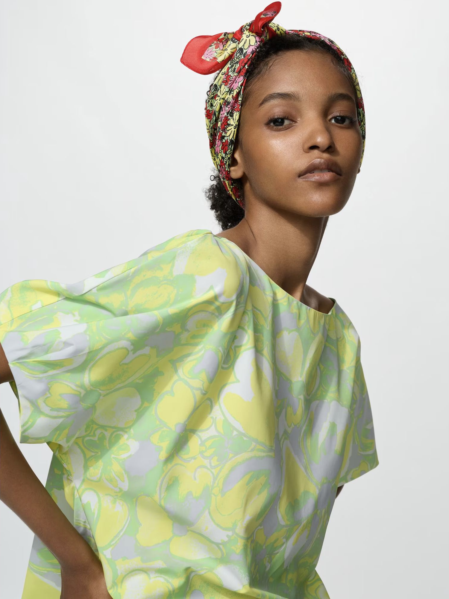 A model wears the Uniqlo flower printed silk scarf tied over the hair