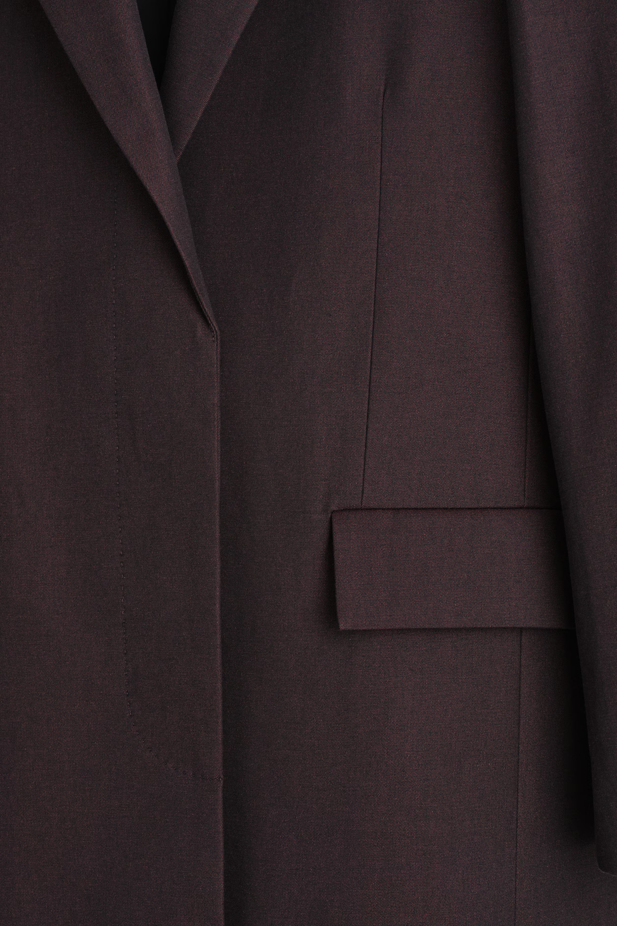 Close view of the burgundy COS coat lapel and front pocket