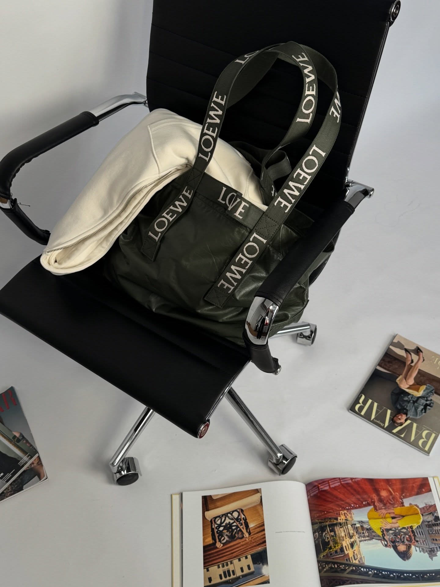 Black Loewe Fold Shopper styled on a chair with magazines and books