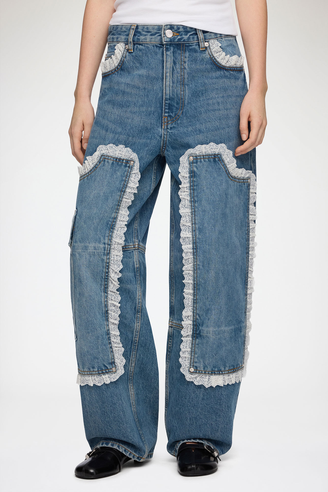 Ganni Audri rigid-denim jeans shown from low waistband through the full wide legs and shoes