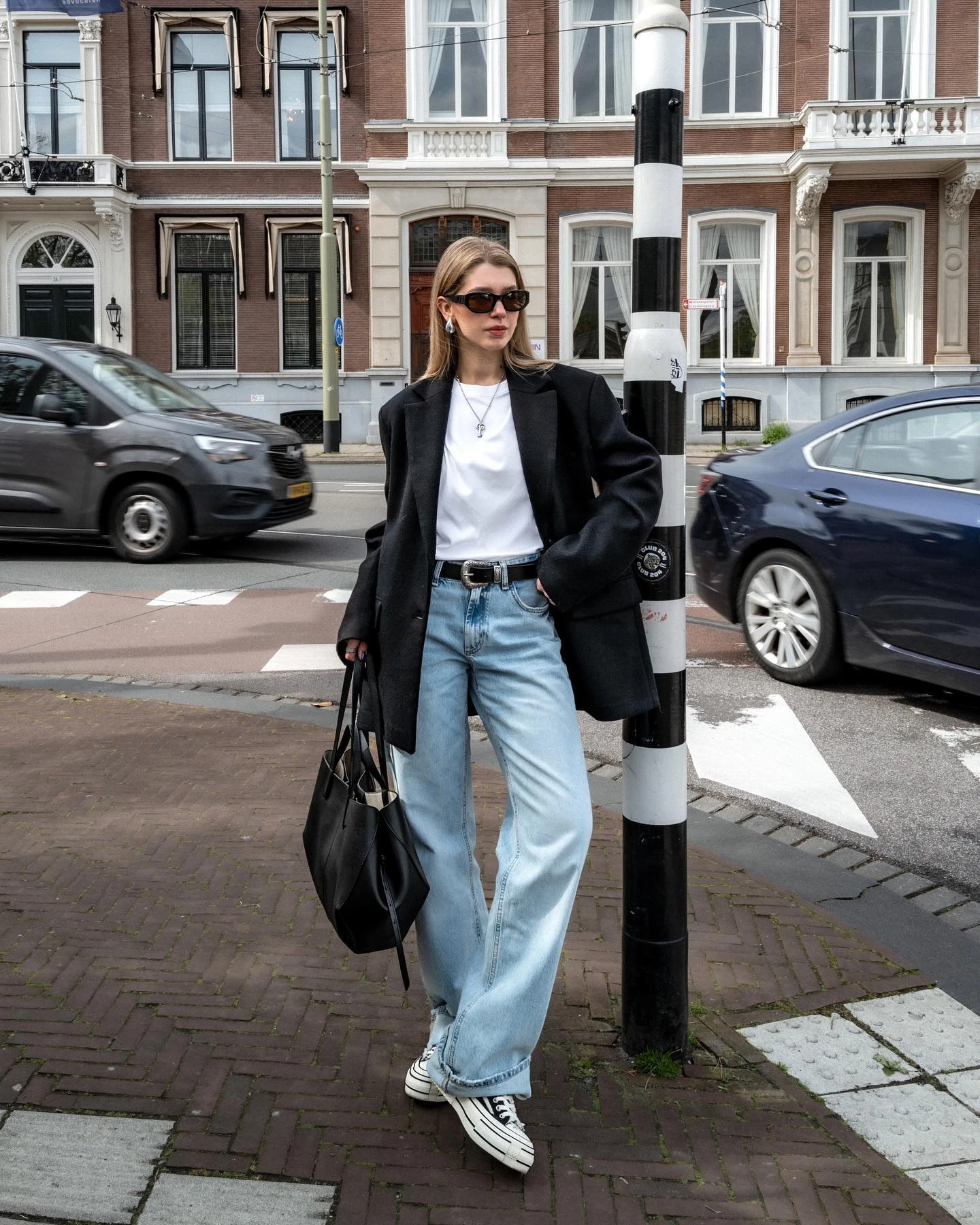 Creator @cvseev in an oversized black blazer, white T-shirt, loose jeans, and sneakers