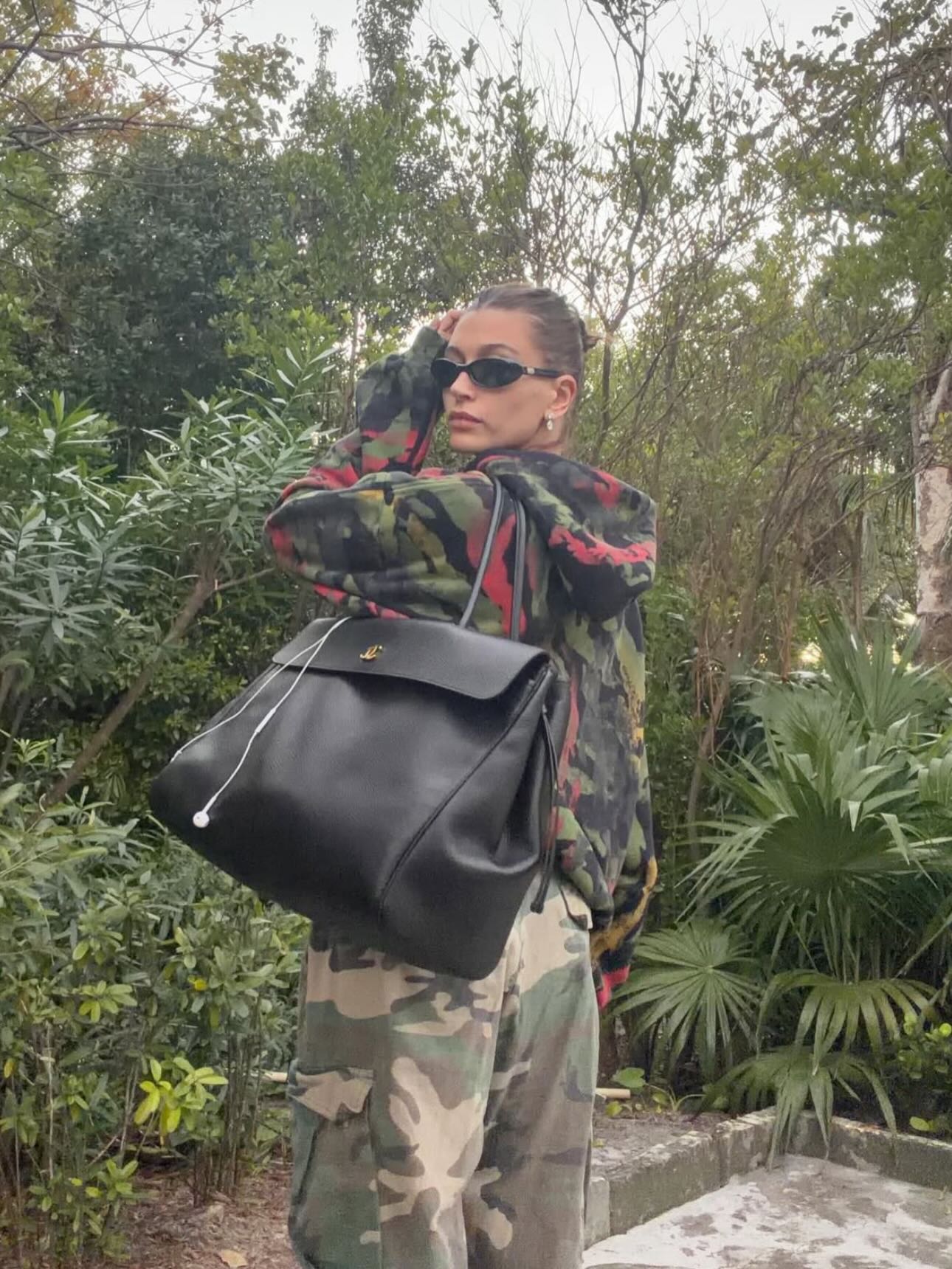 The Row Margaux-style black bag worn with a printed jacket and relaxed trousers