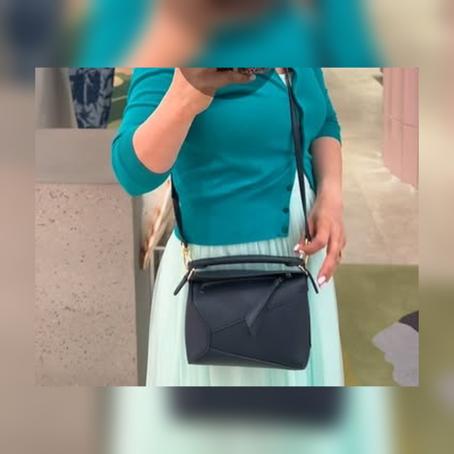 Creator @pharmacistaiha wearing a small black Loewe Puzzle bag crossbody.