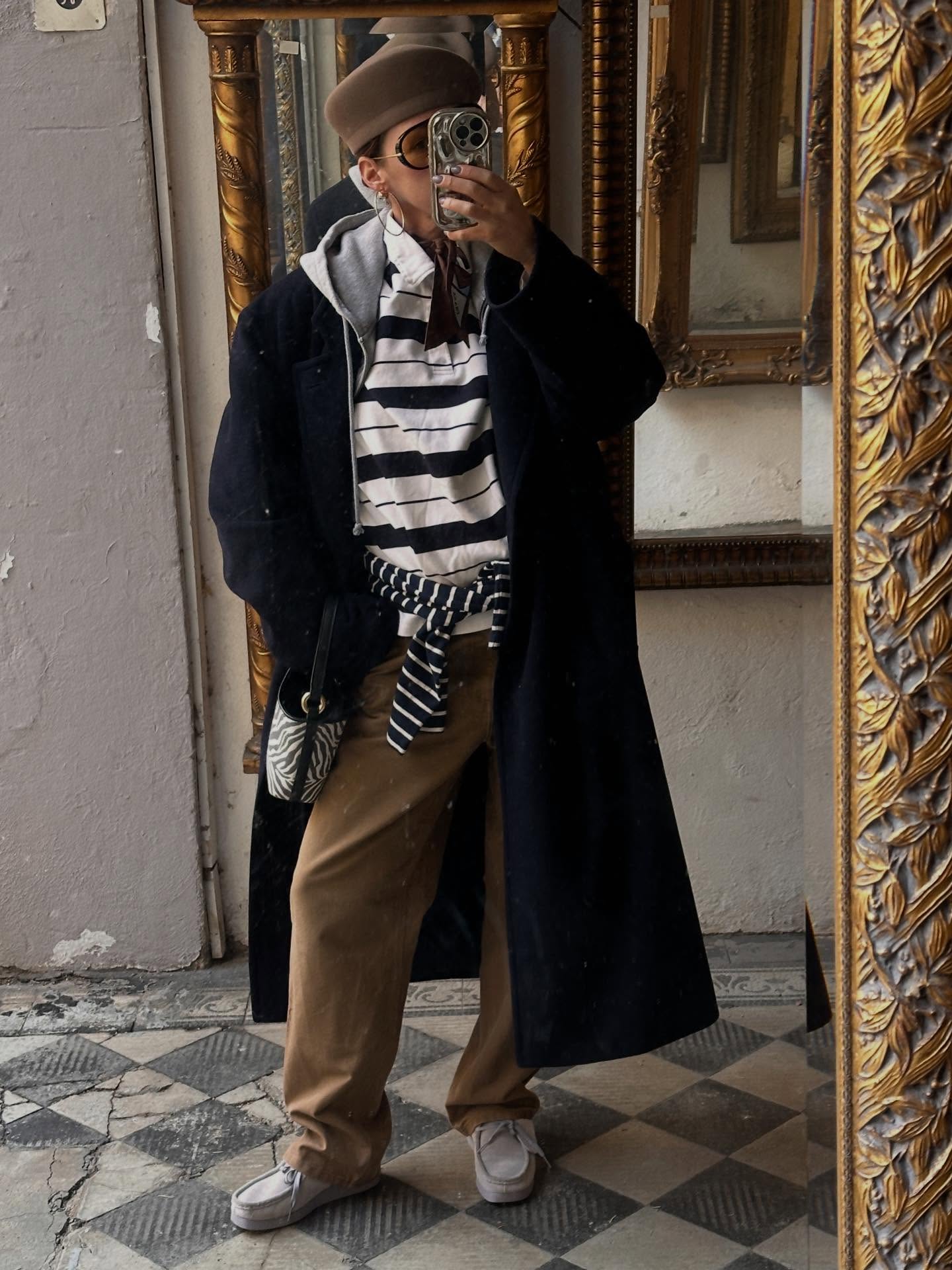 Vintage Jil Sander coat worn with a striped scarf and relaxed trousers in a mirror outfit photo