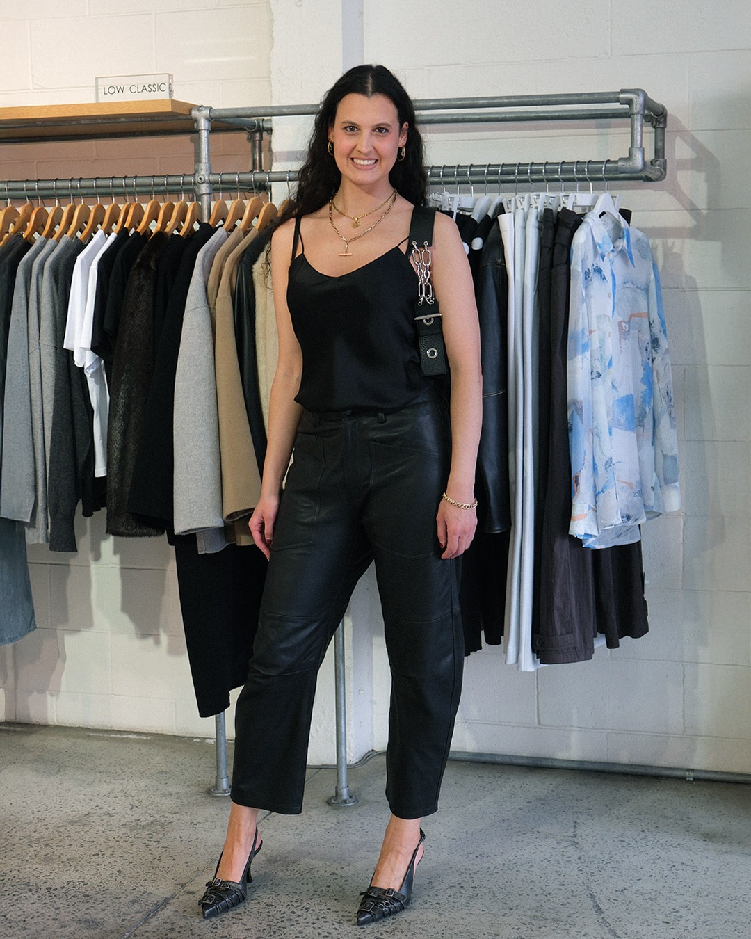 Woman styling a black Acne Studios Musubi Chain shoulder bag with an all-black outfit